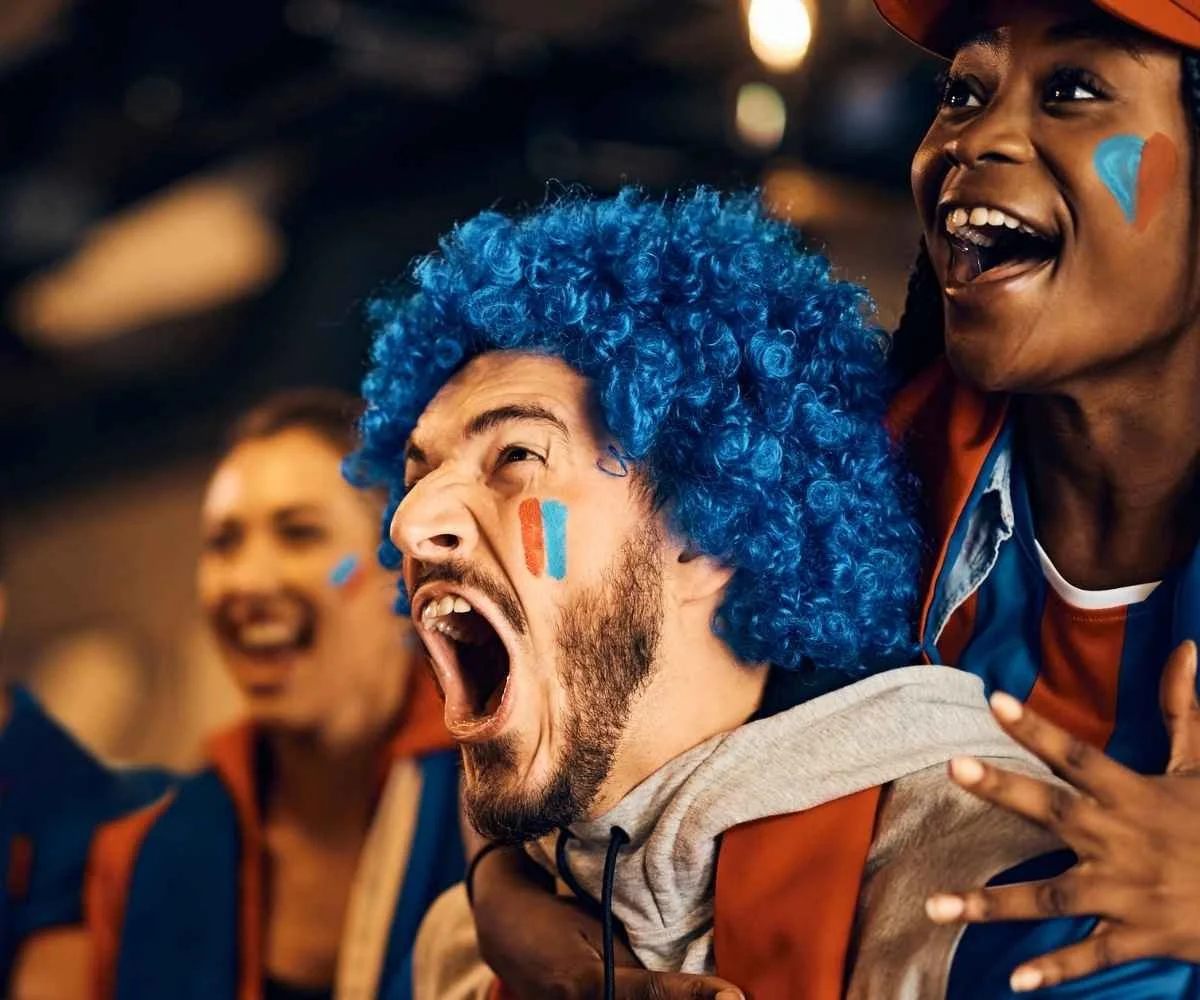 Ecstatic Japan football supporters cheering at the top sports bar in Times Square New York City during a live tournament broadcast.
