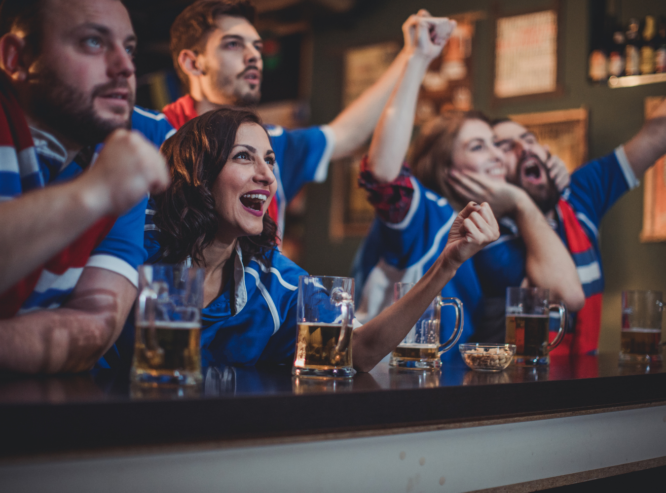 france soccer fans in blue jerseys cheering intensely inside a New York City football factory.
