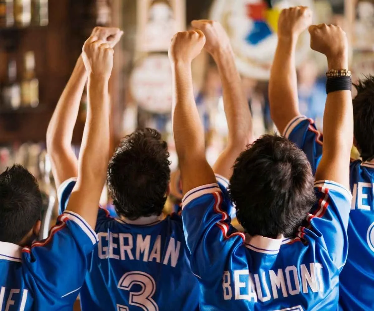Fans cheering in jersey shirts at the best 42nd St World Cup bars in Midtown Manhattan