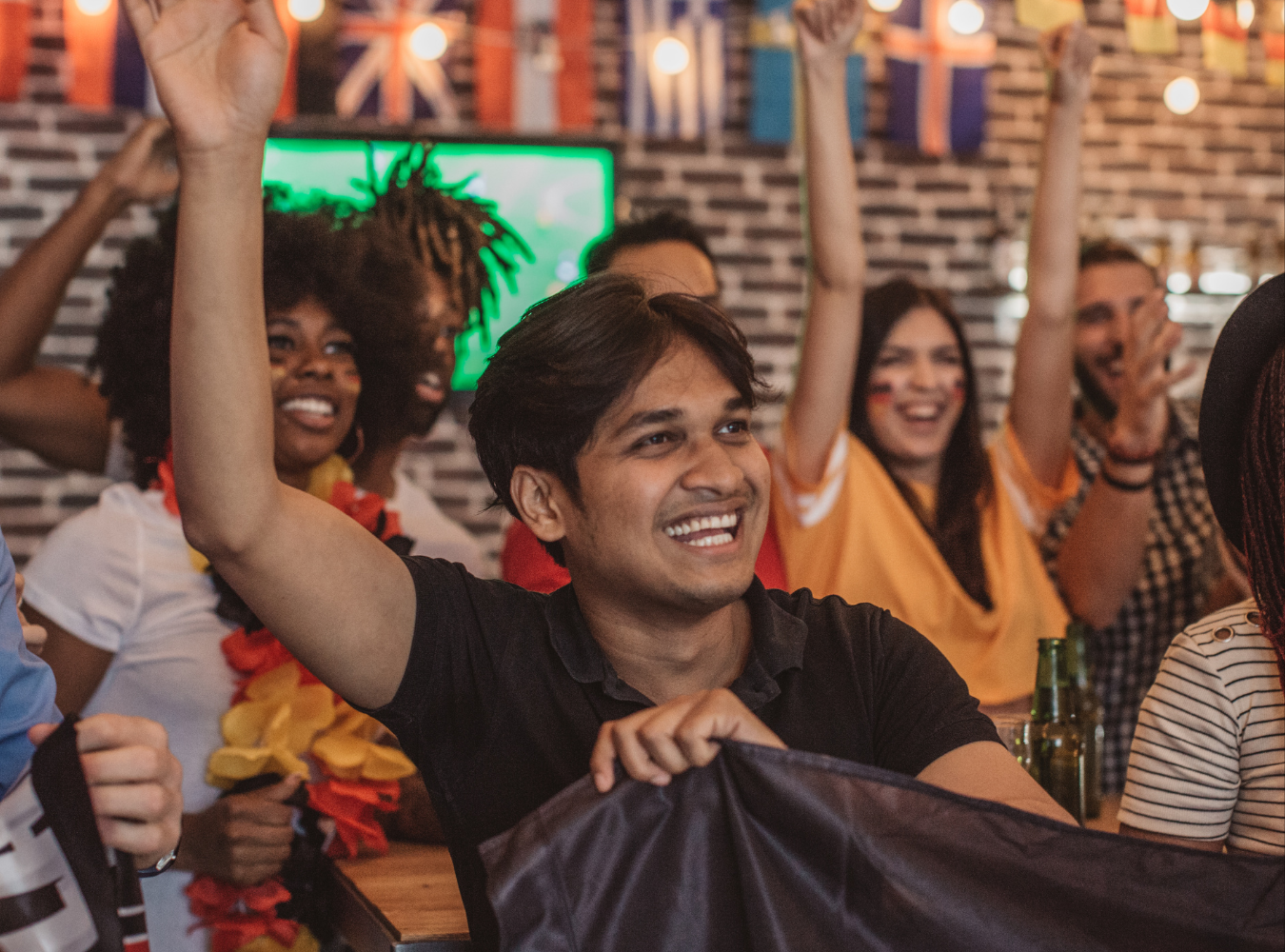 American soccer fans celebrating a victory during a match screening at a Manhattan football bar.