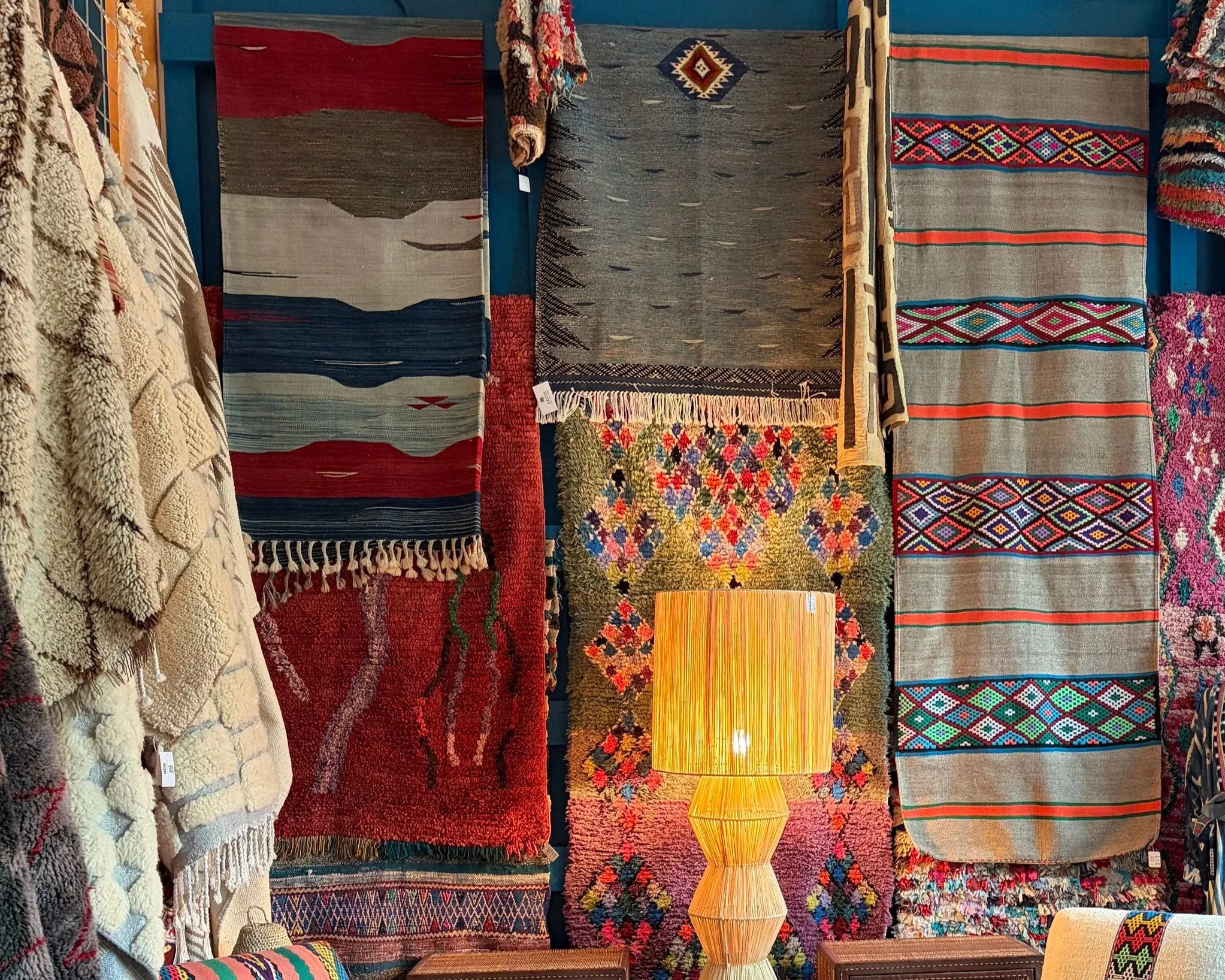 Collection of colorful handmade rugs and textiles with various patterns.