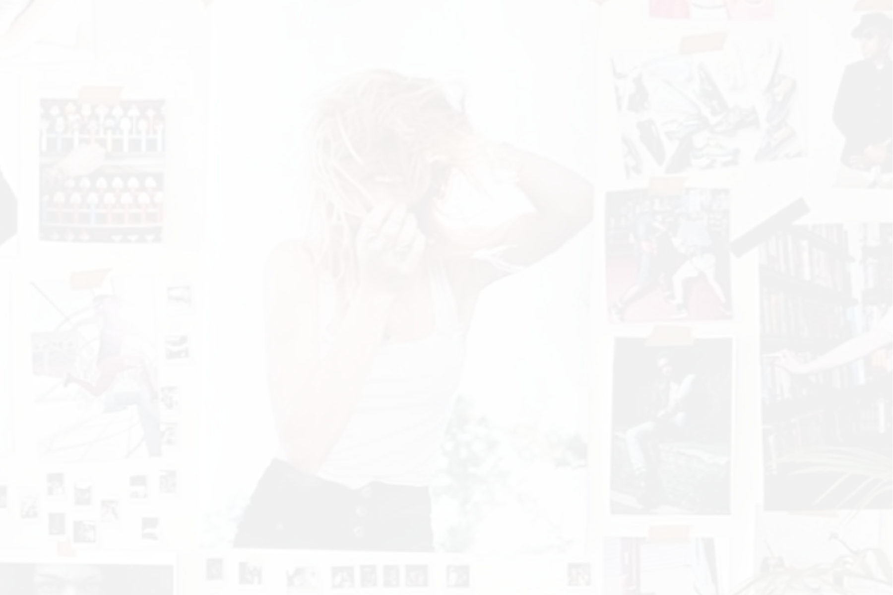 A woman with curly red hair adjusting her hair in front of a photo collage on a white wall. The collage includes various images of people, books, and artwork.