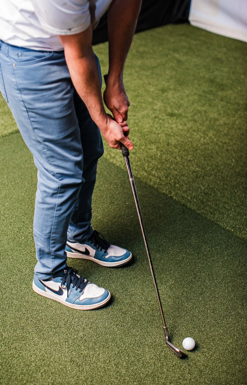 Man swinging a golf club at an indoor golf simulator in Fairburn Georgia