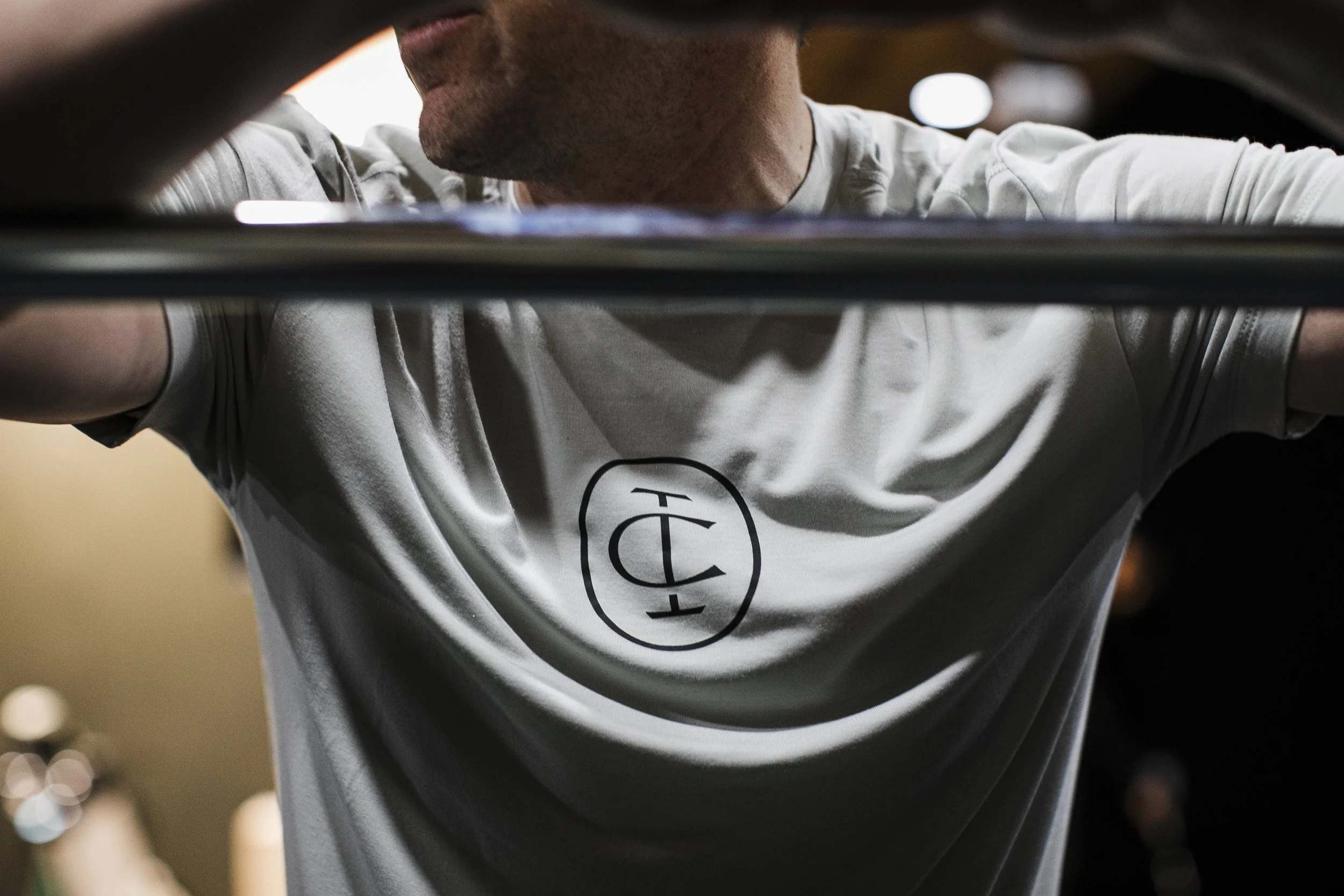 Man with a barbell lifting weights at an Iron Club gym in Fairburn Georgia with an indoor golf simulator