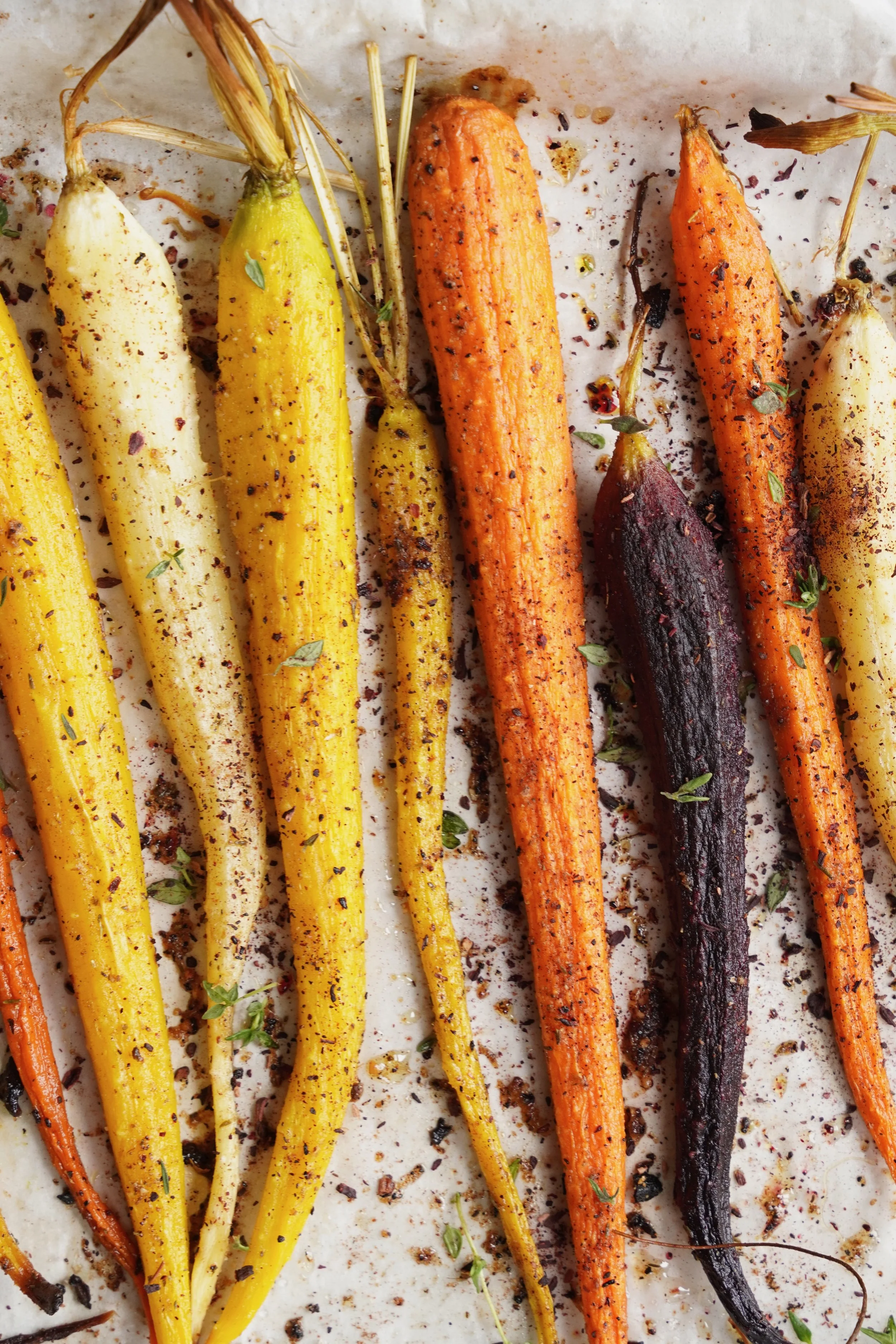 Detail shot of a variety of roasted carrots with spices and sorrel rub
