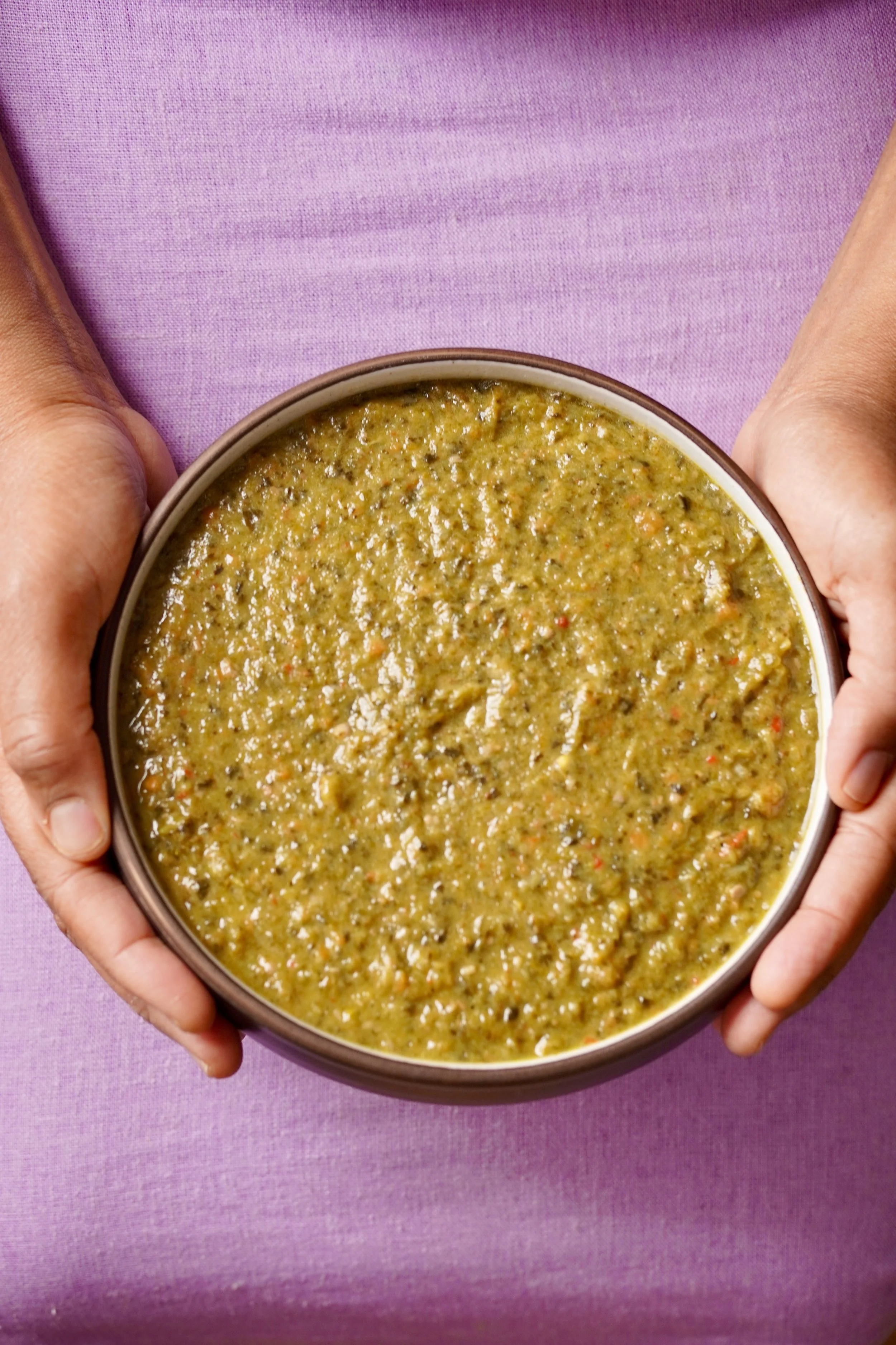 Close up image of callaloo presented in a round ceramic bowl