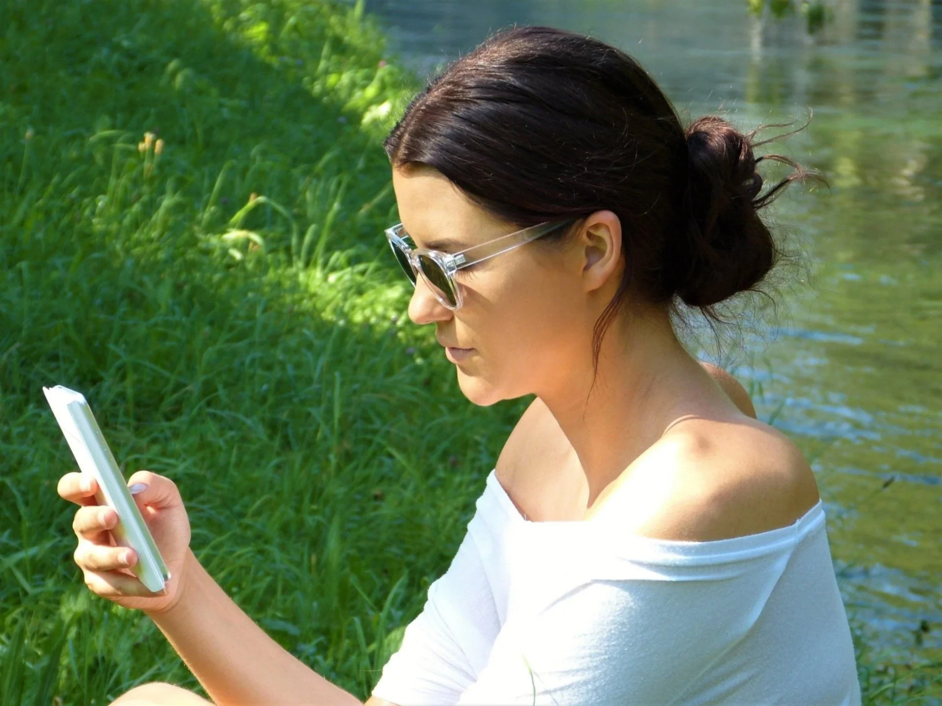Femeie care citește un mesaj pe telefon în natură — Roxana Colțea - coaching și programe de wellbeing
