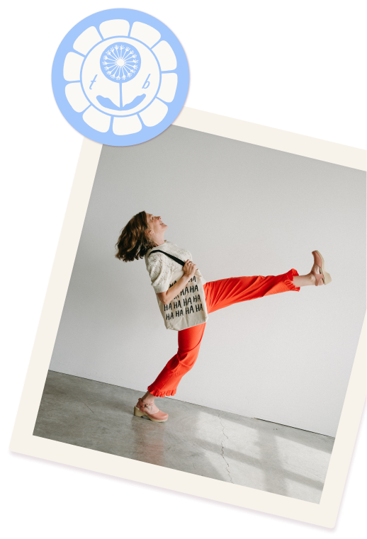 coach tammie bennett walks joyfully kicking one foot high in the air. she wears flame red pants and a cream white top.