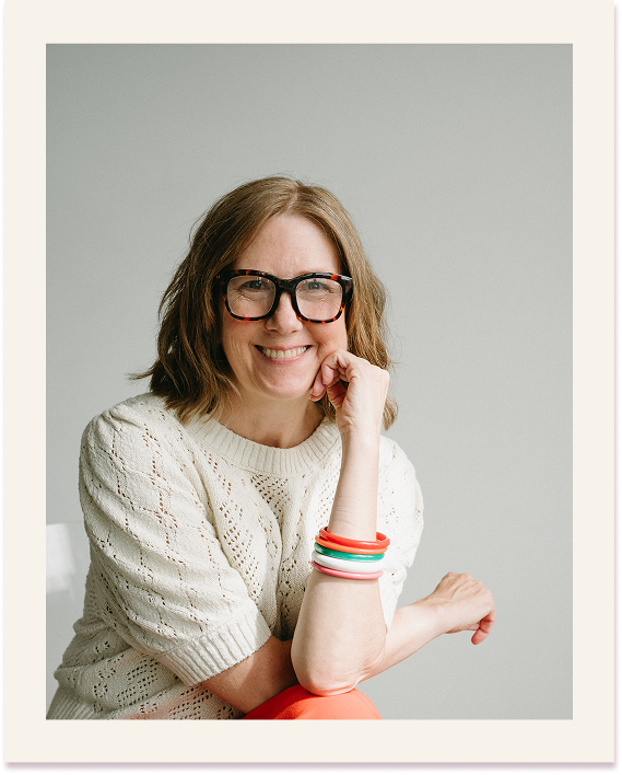 coach tammie bennett smiles at the camera wearing glasses, and colorful bangle bracelets