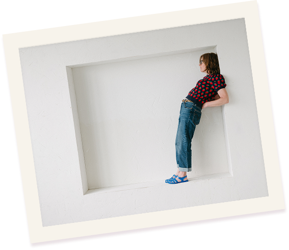 coech tammie bennett stands in an opening with her back arched. she is wearing blue jelly shoes.