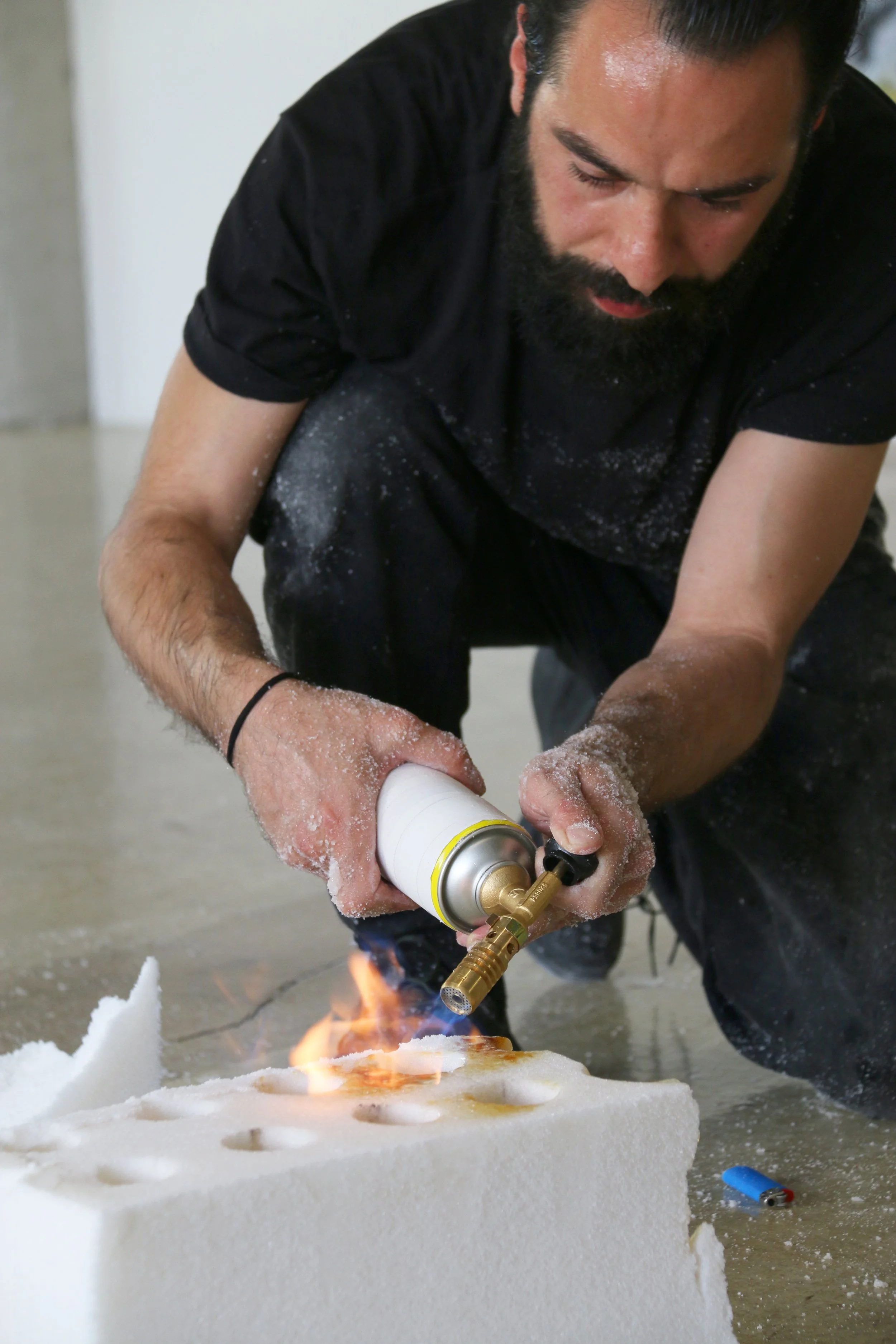 Foto von der Performance Sugar forever von Fadi Al Hamwi: Der Künstler bearbeitet einen Zuckerziegel mit einem Bunsenbrenner