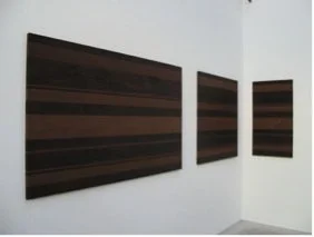 Helga Weihs, WO-17-18-15-2013, Thermoesche geölt, Stahl geschraubt - Wandrelief aus dunklem Holz, bei dem die unterschiedlich großen Elemente mit der streifenartigen unterschiedlichen Holzfärbung im Raumwinkel in abstrakter Anordnung gehängt sind.