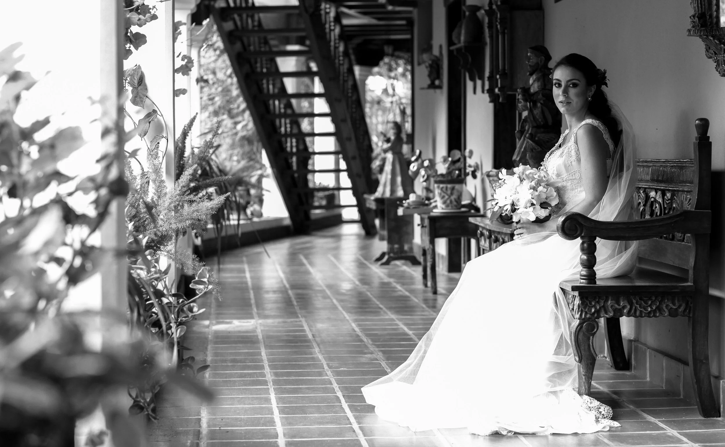 A timeless black and white portrait of the bride seated in soft light, blending classic elegance with quiet introspection.
