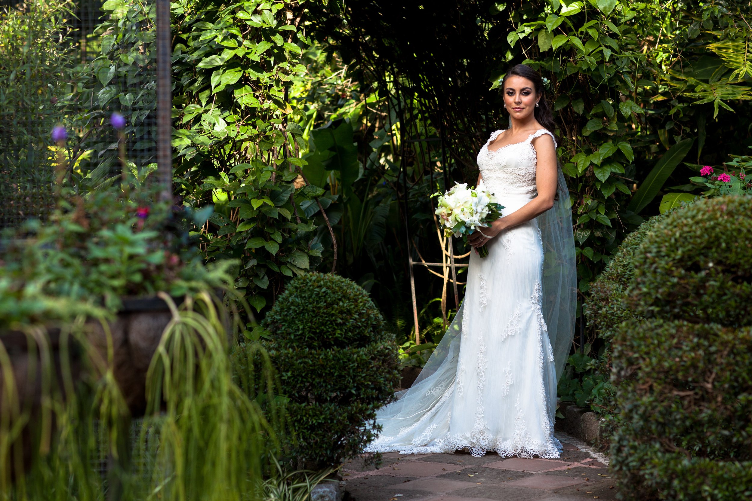 Surrounded by lush greenery, the bride stands in soft natural light, closing the story with a sense of calm and romance.