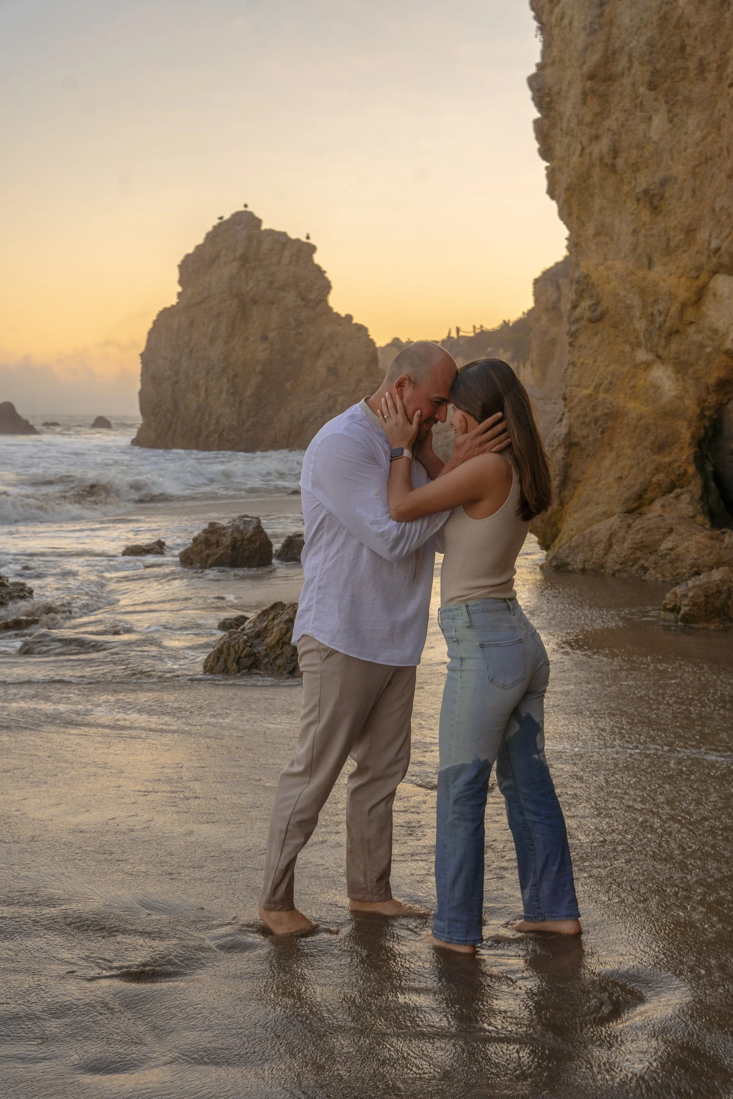 A still, emotional portrait capturing a quiet connection—subtle, grounded, and deeply personal against the coastal backdrop.