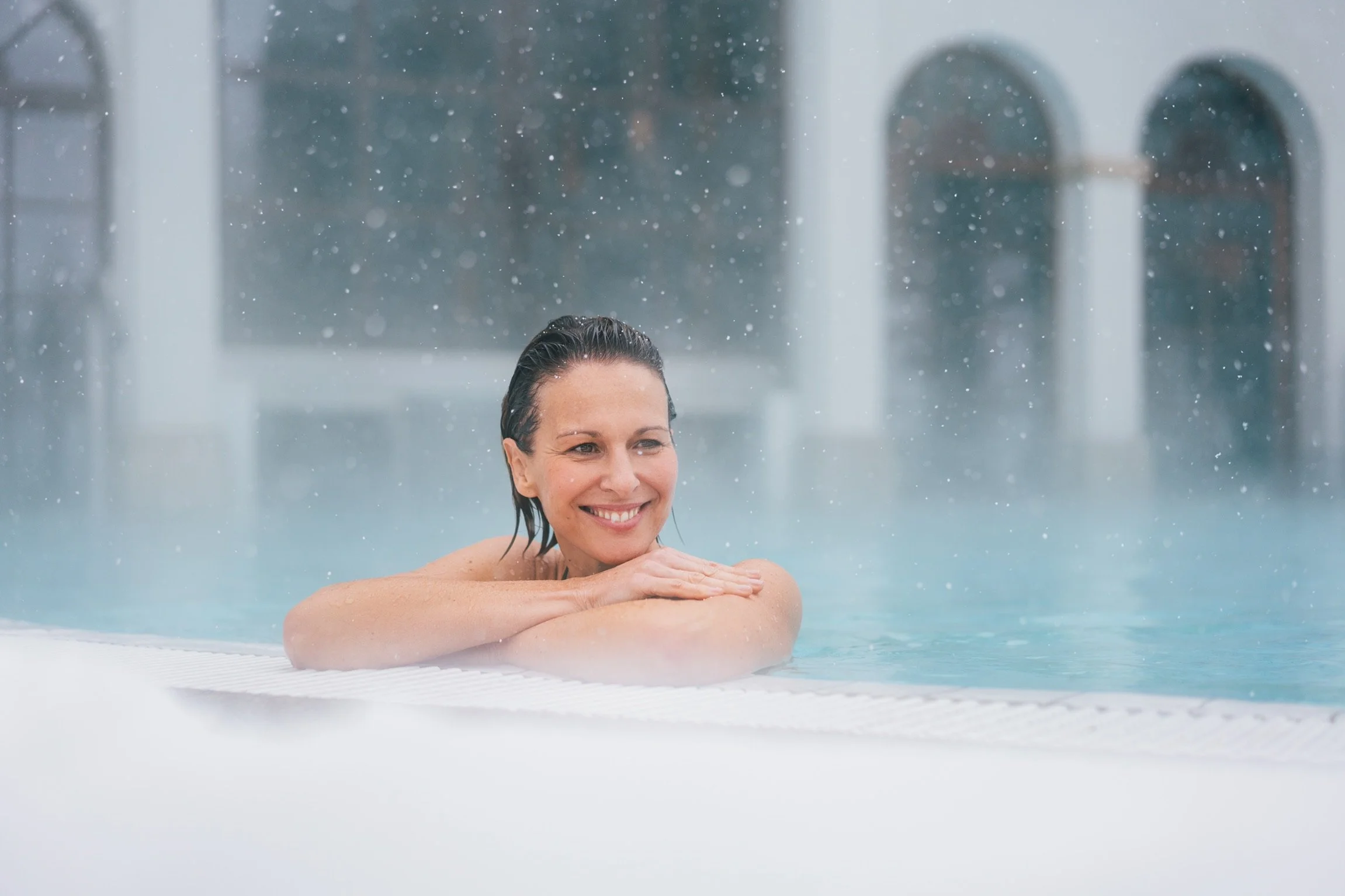 Frau entspannt im Whirlpool beim Regenerieren im Spa.