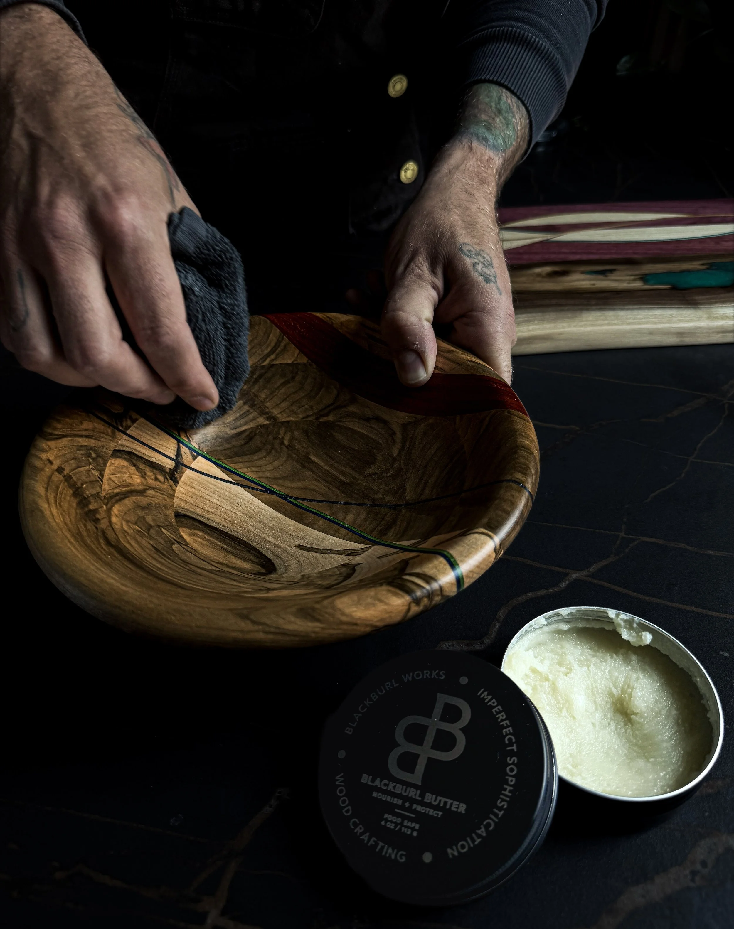 Hand applying Blackburl Butter wood conditioner to a handcrafted hardwood bowl during the finishing process at Blackburl Works in Fernie, British Columbia, Canada.