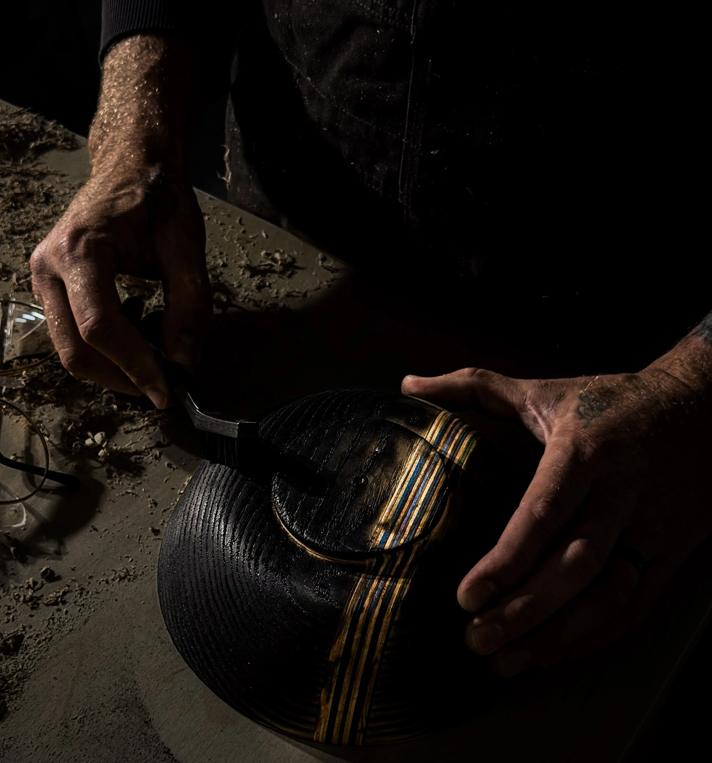Close-up of a handcrafted shou sugi ban bowl being brushed by hand to reveal the grain after charring. Featuring a recycled skateboard inlay, each Blackburl Works bowl is crafted one at a time in Fernie, British Columbia, Canada.
