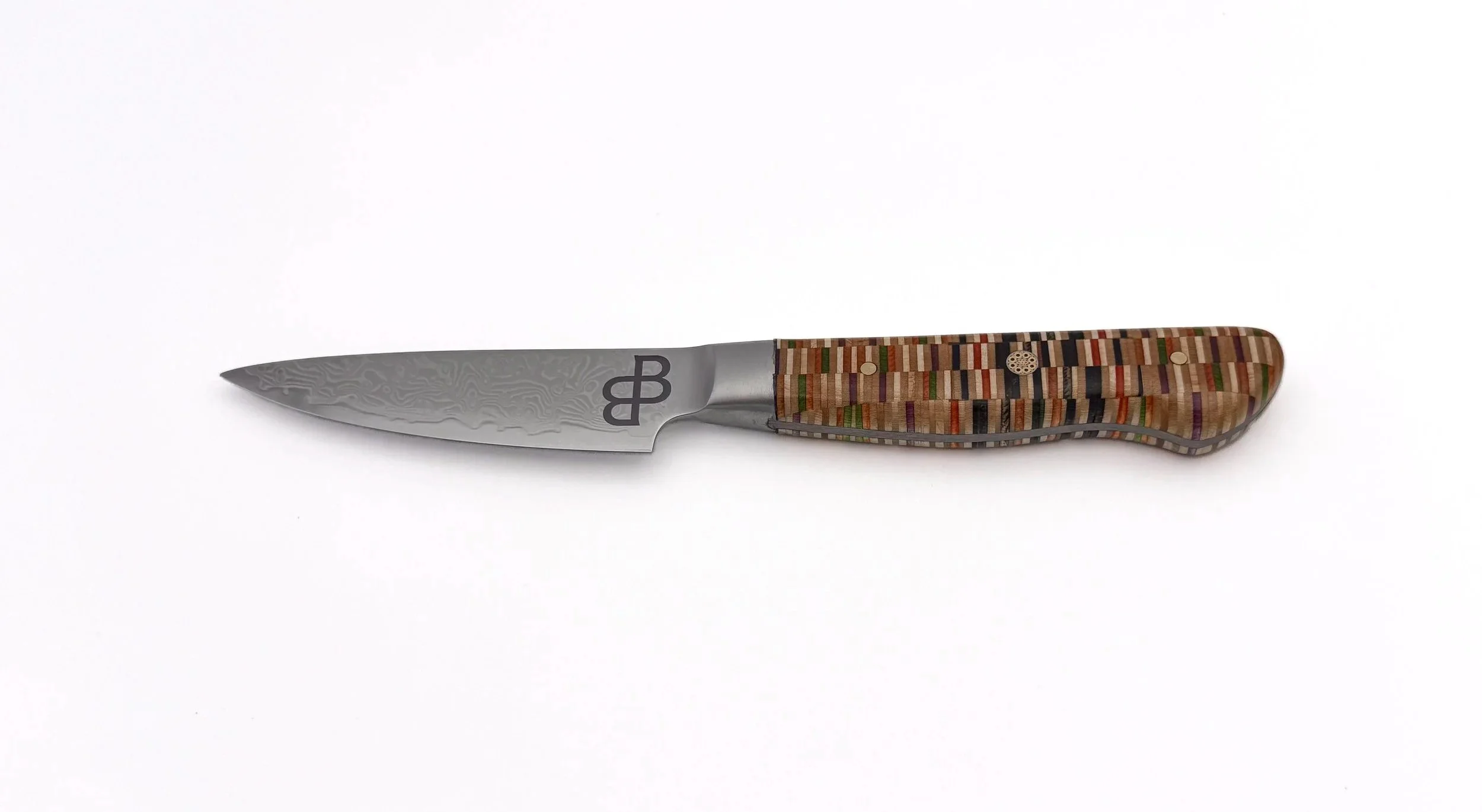 Handcrafted Damascus chef knife with recycled skateboard handle by Blackburl Works on a clean white background.