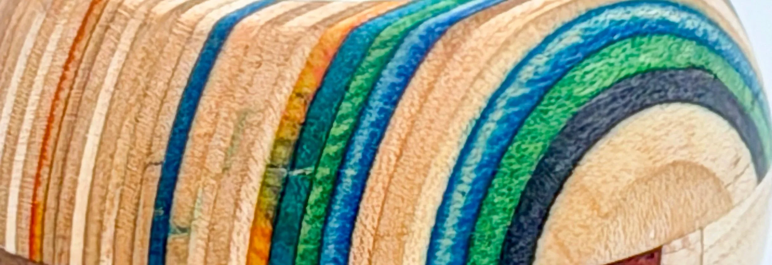 Close-up of colourful recycled skateboard veneer integrated into handcrafted hardwood design.