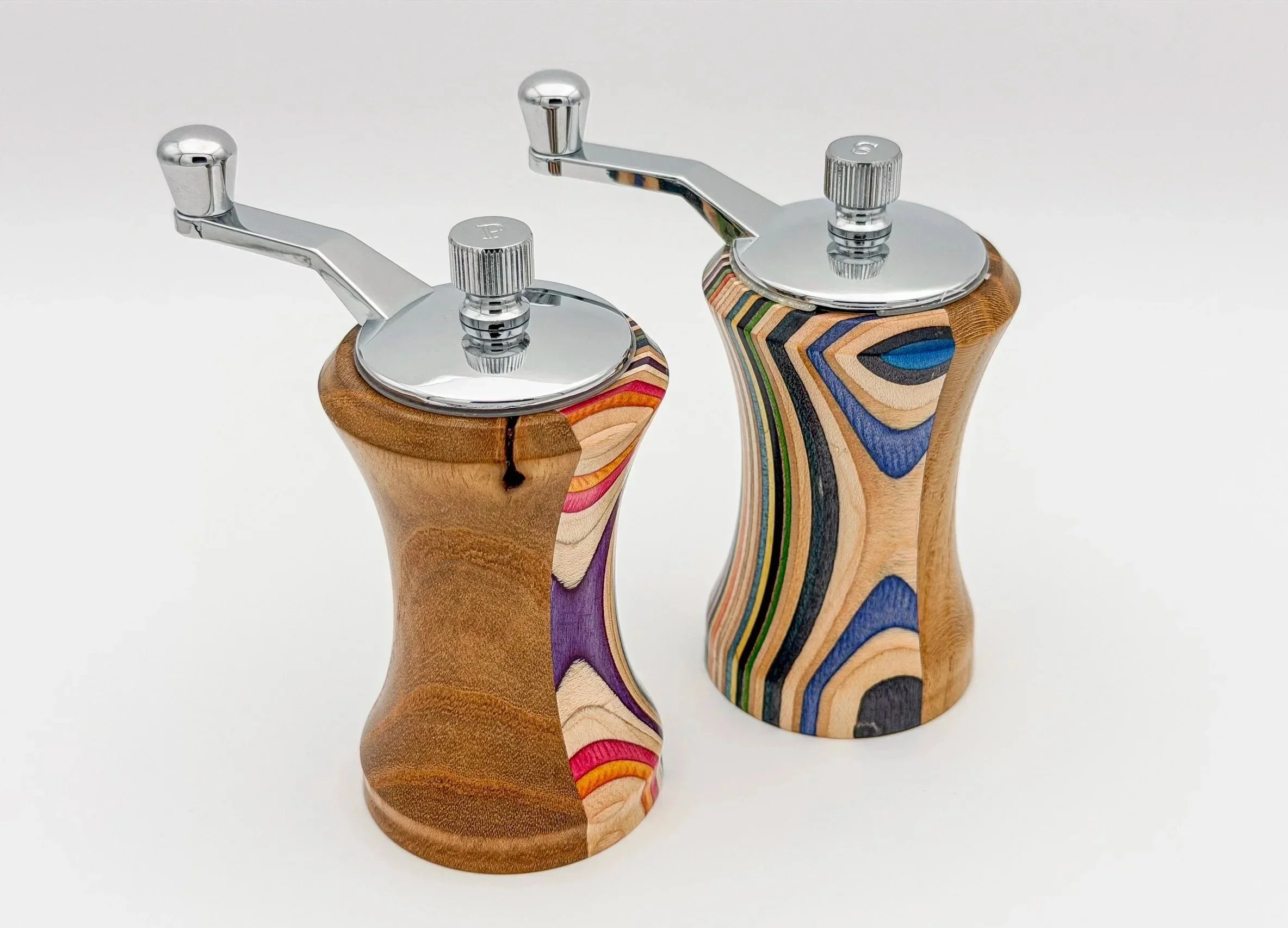 Two handcrafted wooden salt and pepper shakers with chrome tops and levers, featuring colorful layered wood patterns.
