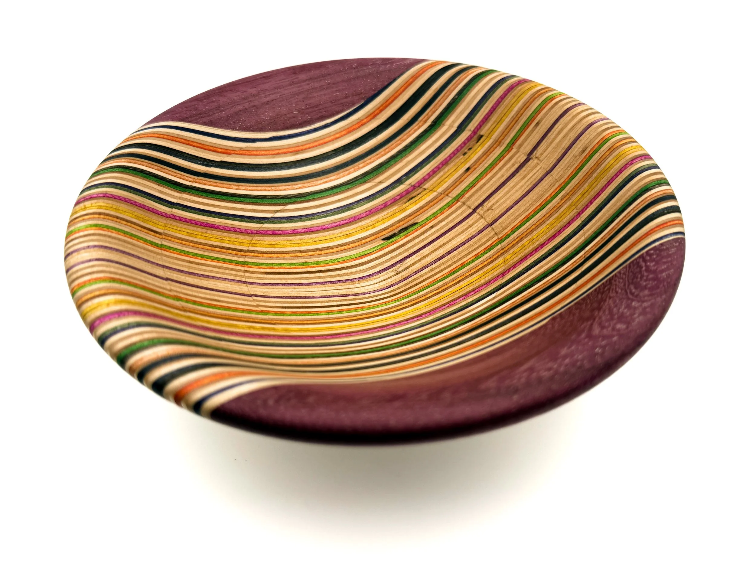 Close-up of a colorful striped ceramic bowl with a glossy finish.