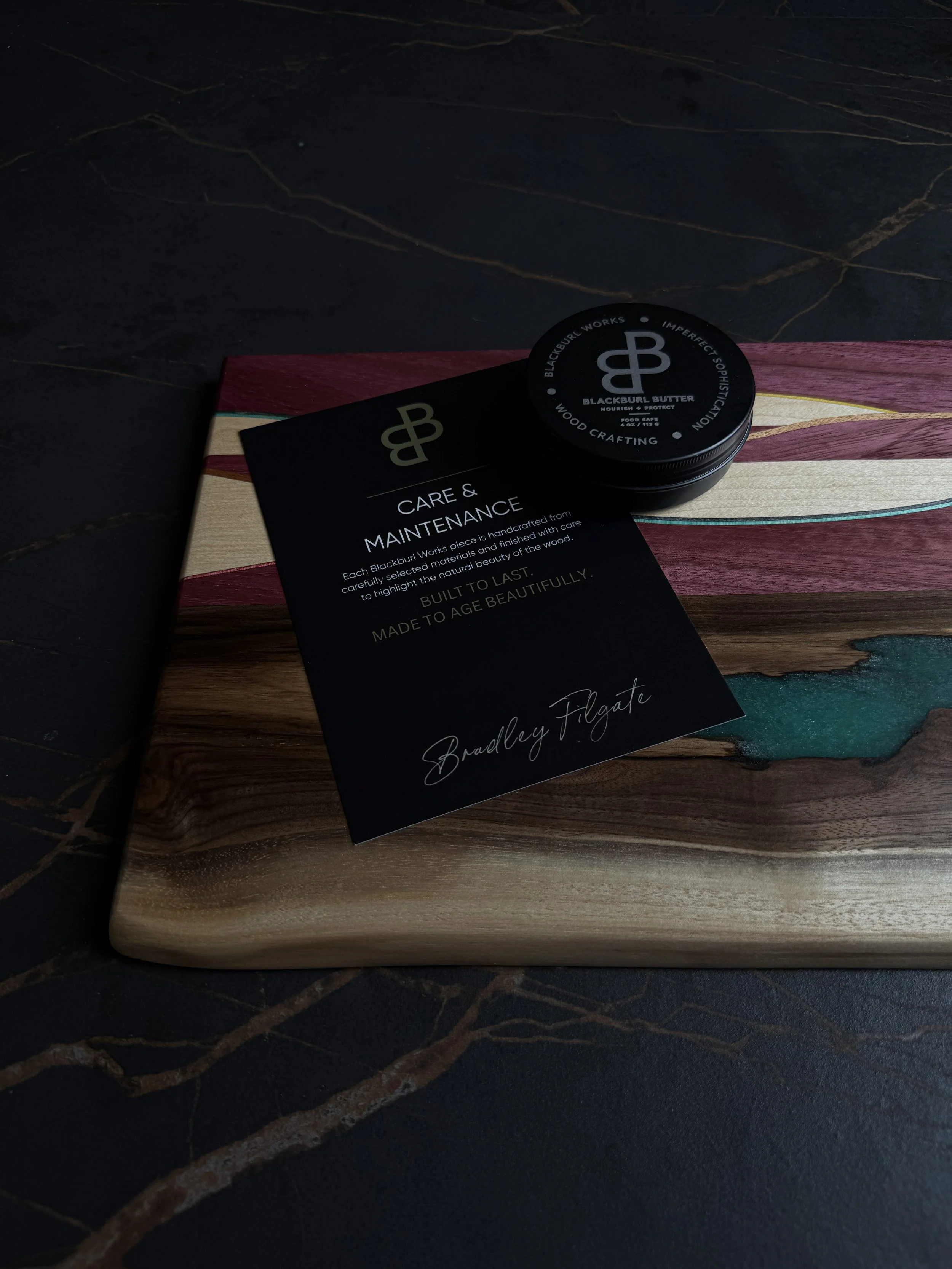 Blackburl Butter wood conditioner and care card displayed on a handcrafted serving board by Blackburl Works.