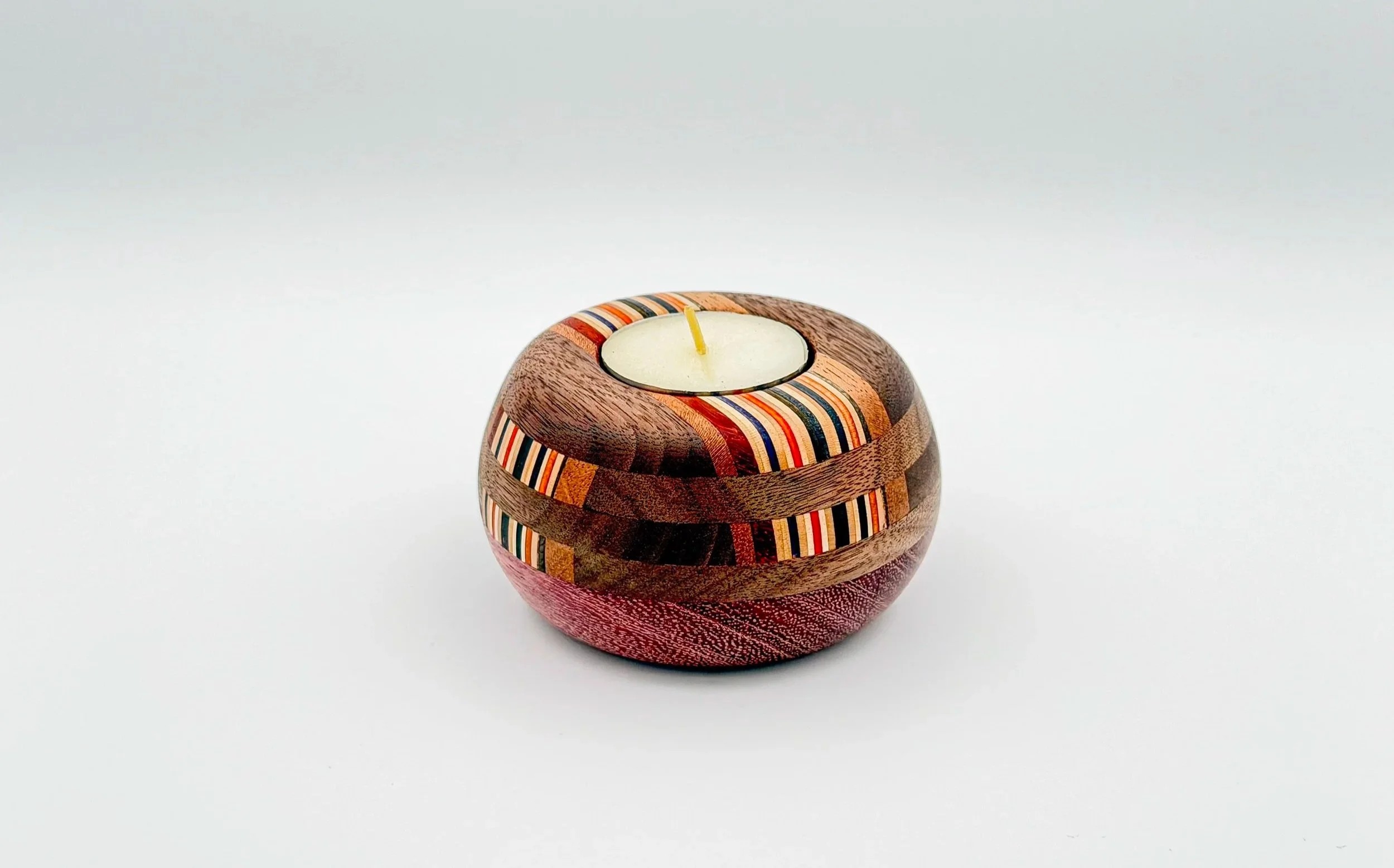 Handcrafted hardwood tea light candle holder with recycled skateboard wood accents.