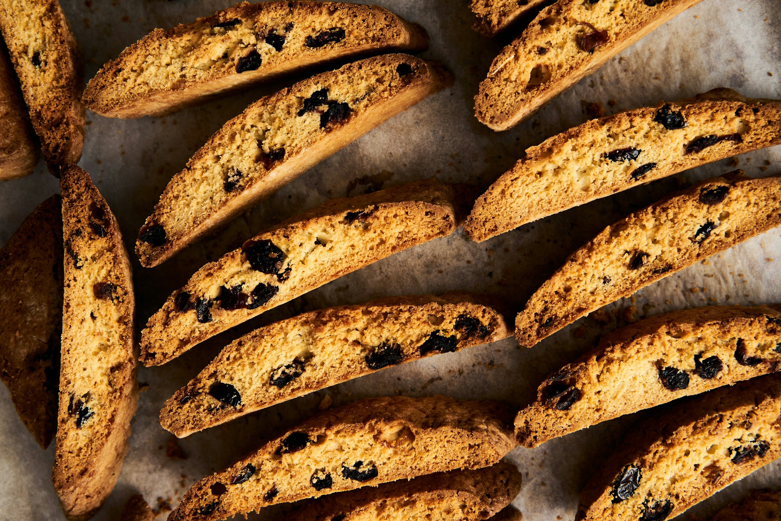 Several biscotti with visible chocolate, crispy texture, arranged overlapping on parchment paper.