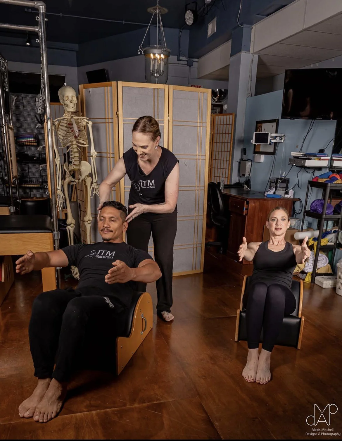 Pilates teacher working with two students