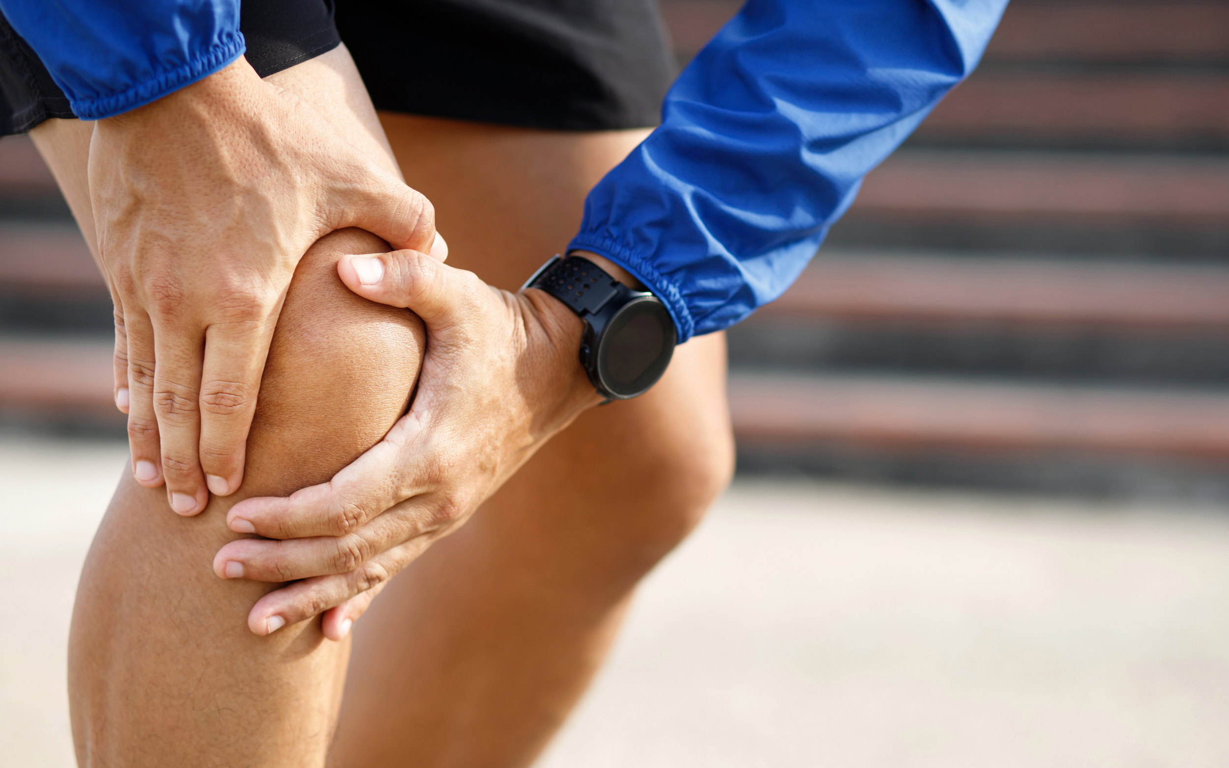 Person gripping knee in pain