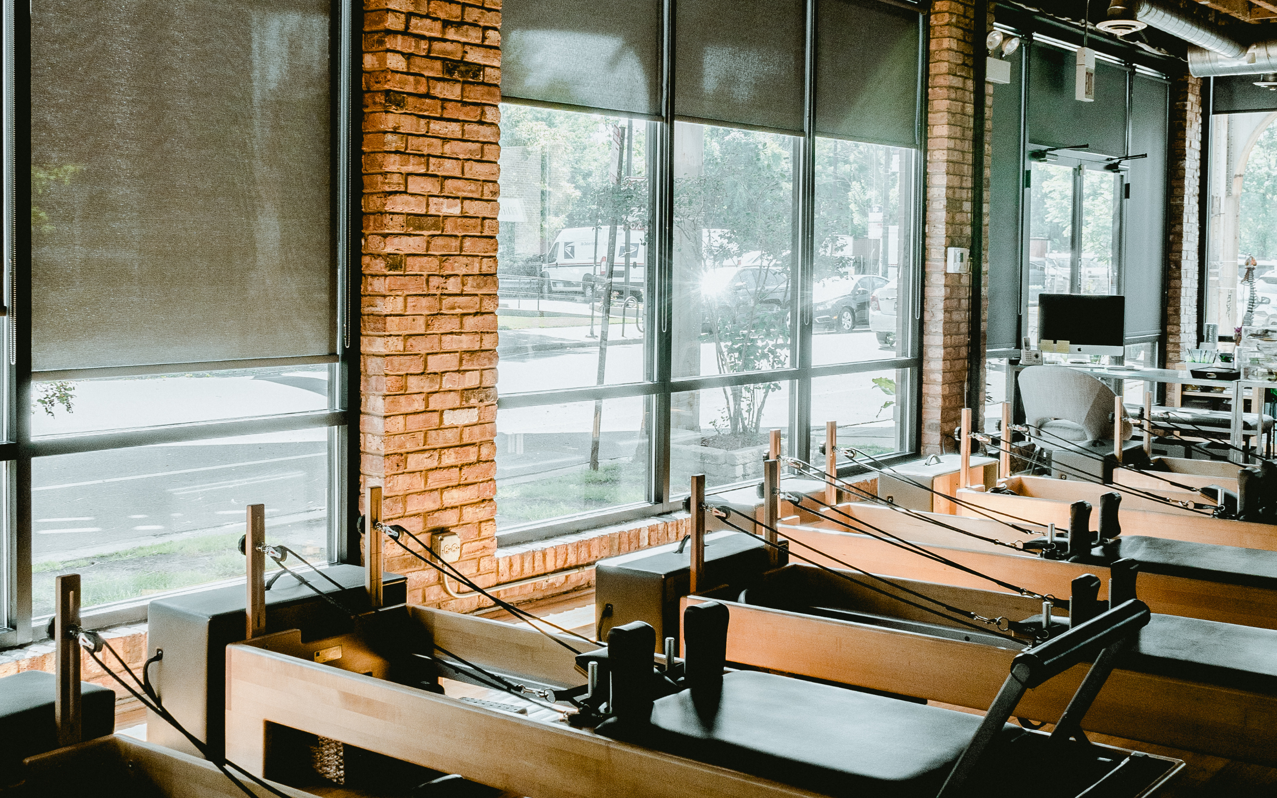Multiple pilates reformer machines by windows.