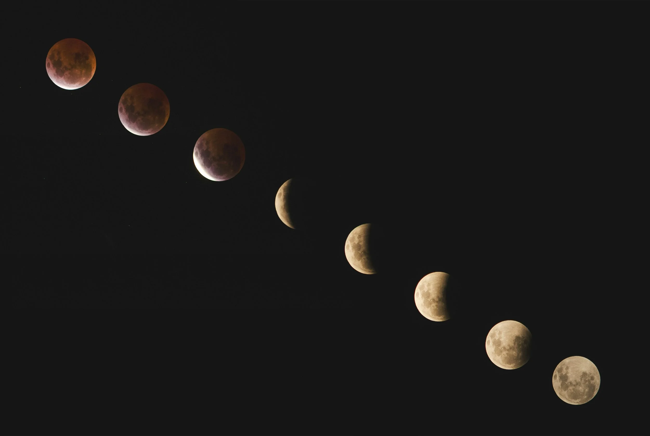 Sequence of moon phases against a black sky