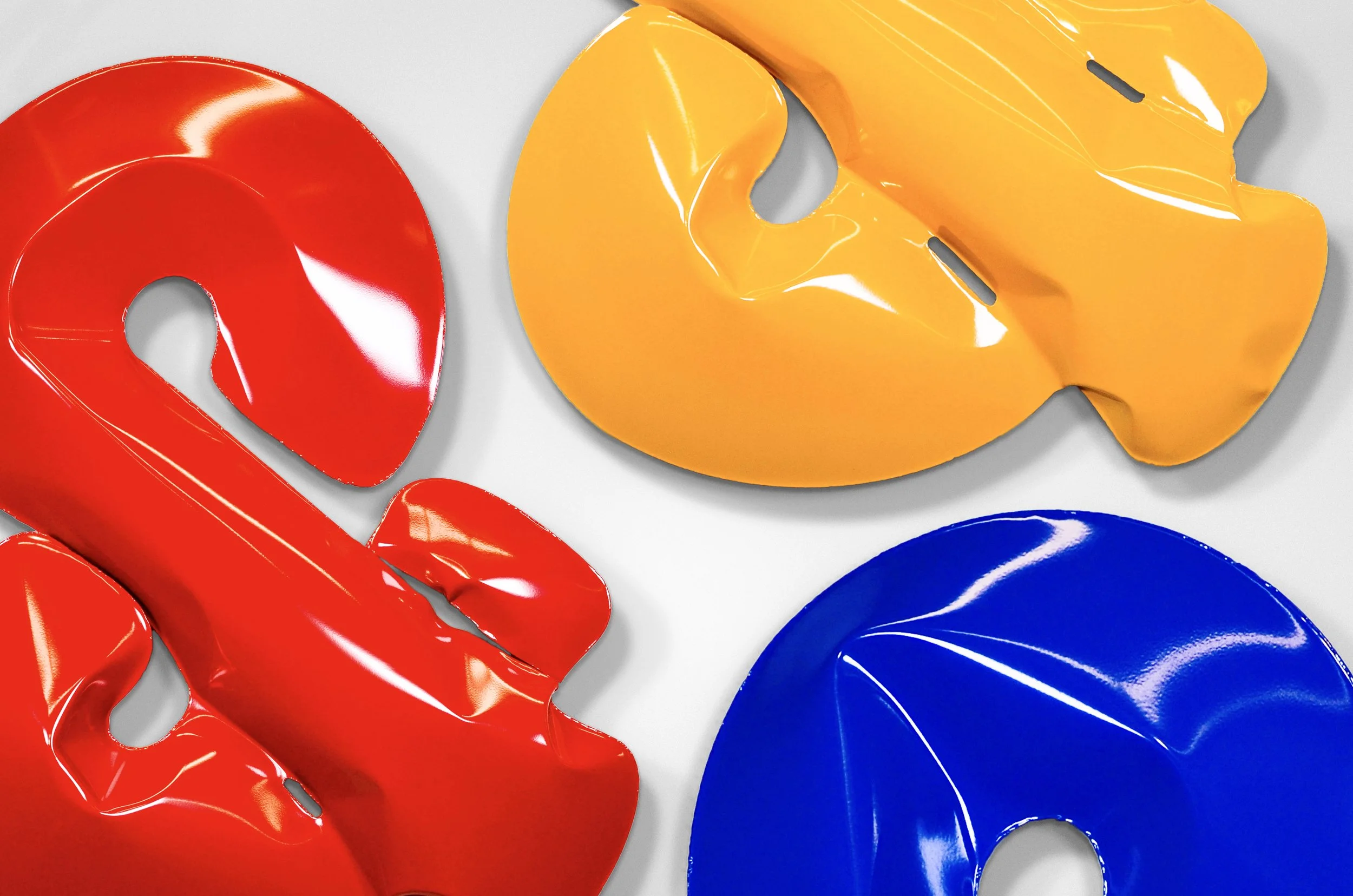 Colorful abstract ampersand sculptures made of steel and powdercoated bright red, yellow, and blue.