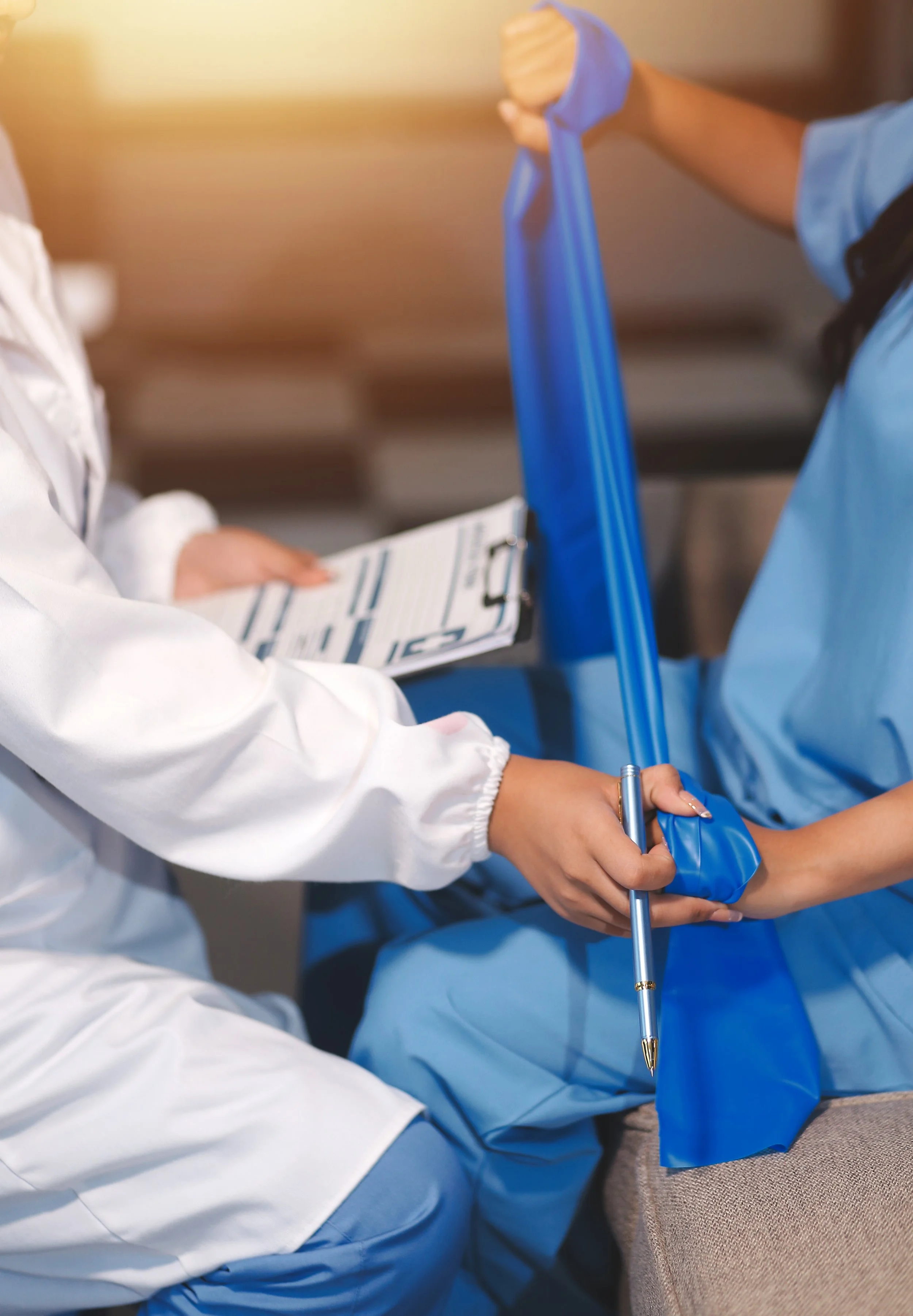 A physical therapist in a white coat providing guided resistance band strengthening exercises and therapy to a patient recovering from a car accident in a Manhattan clinic.