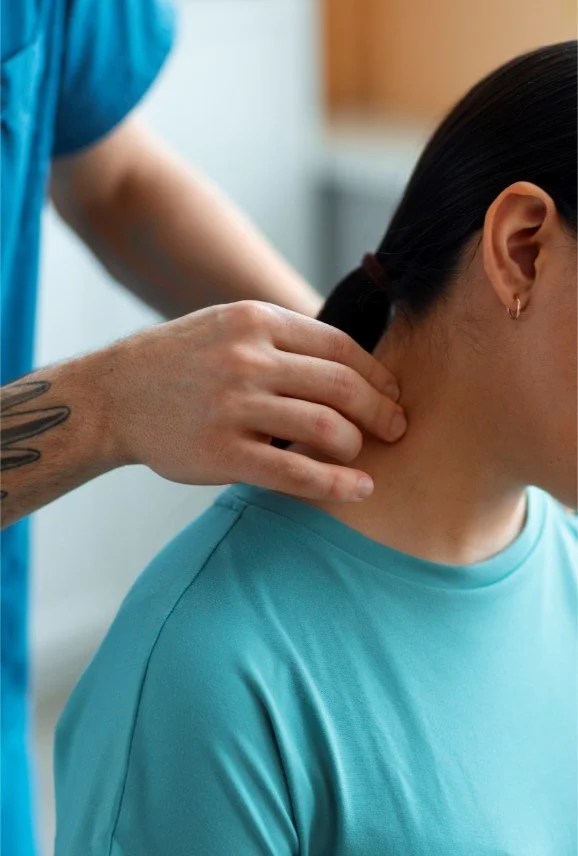 A physical therapist at Signature PT performing manual soft tissue mobilization and trigger point therapy on a patient's neck in a Manhattan clinic.