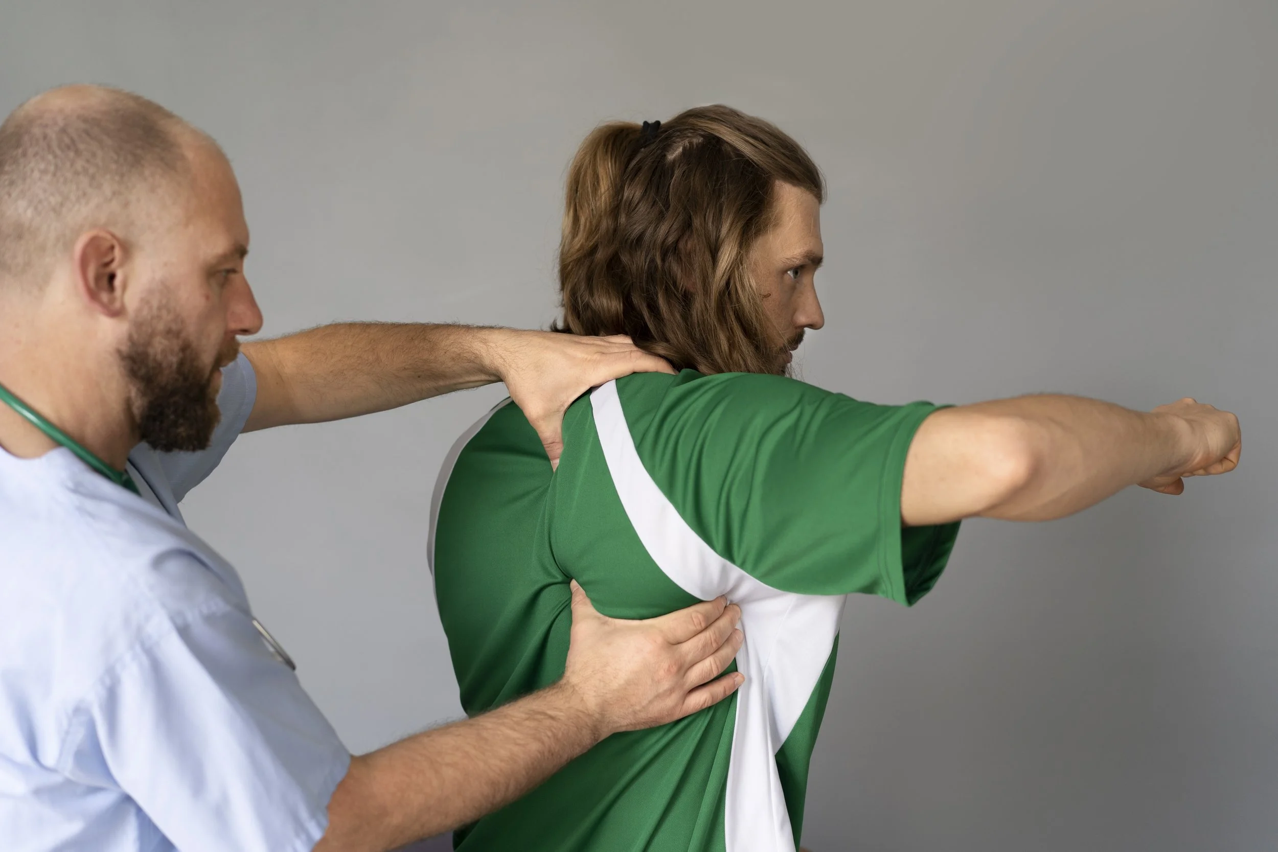 A professional physical therapist at Signature PT performing manual shoulder mobilization and stabilization on an athlete in Manhattan.