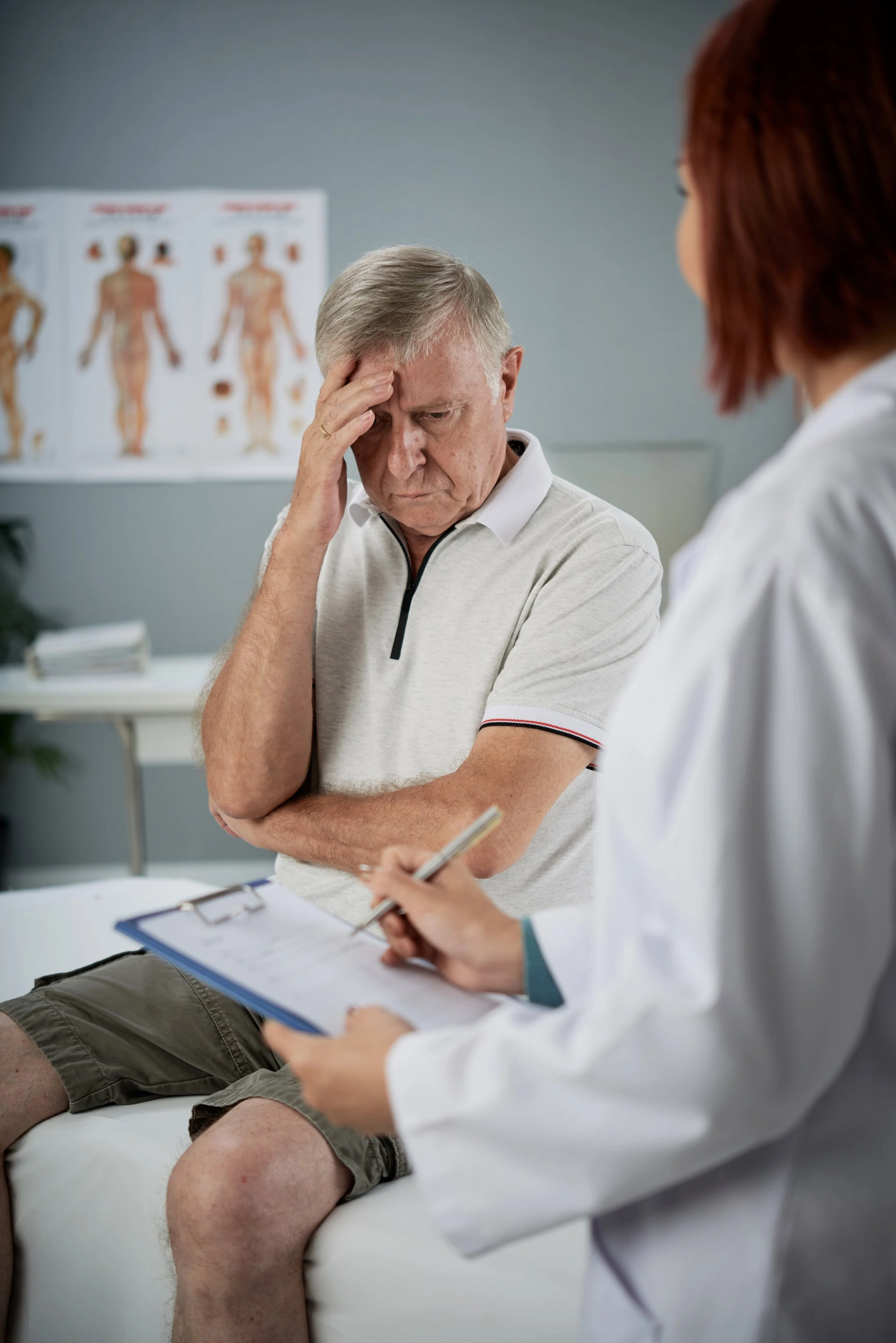 A physical therapist in a white coat at Signature PT performing a clinical intake and neurological evaluation for a patient with chronic nerve pain.