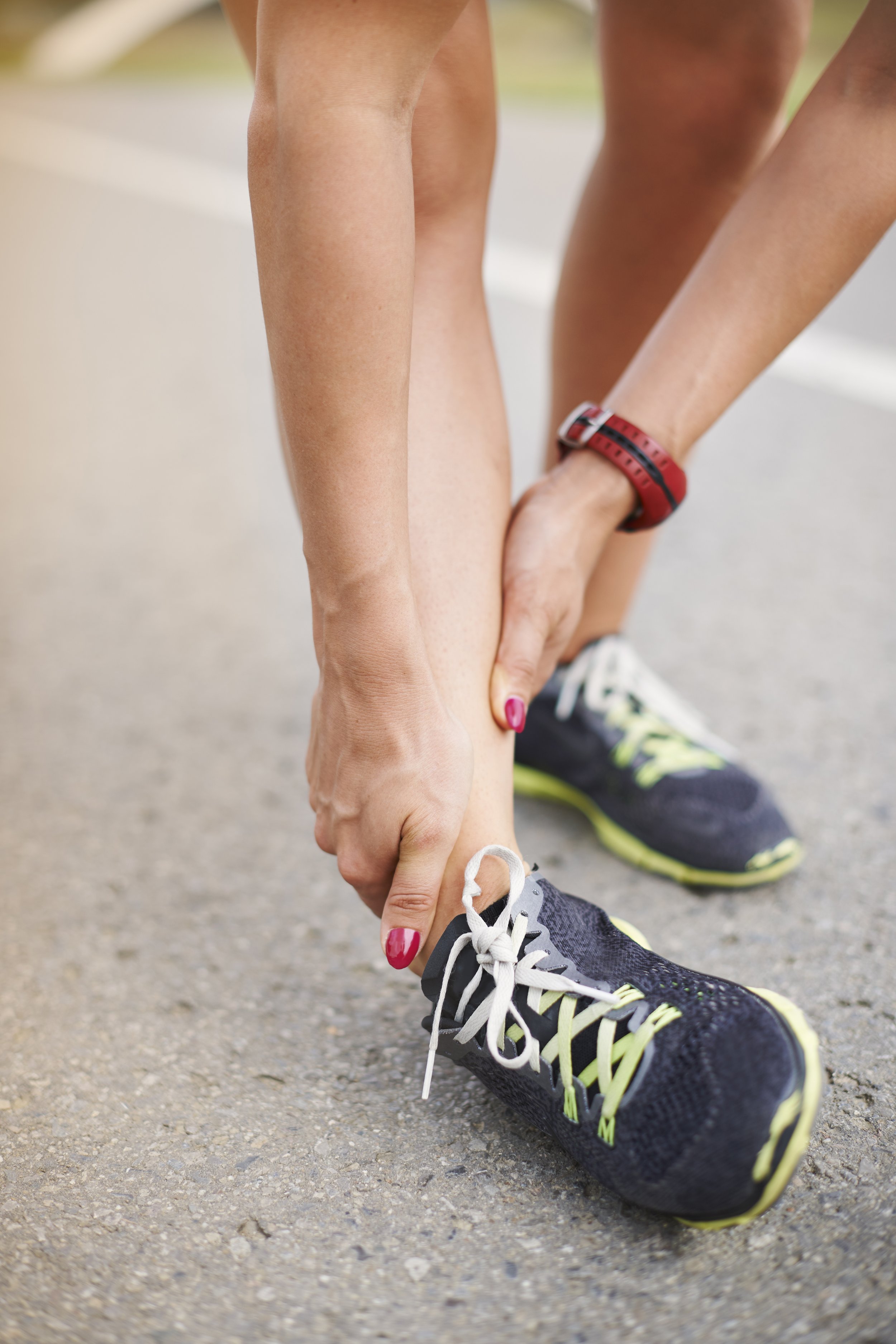 Close-up of a person with a bright red pain indicator over the Achilles tendon and back of the ankle, illustrating symptoms of tendonitis and inflammation.