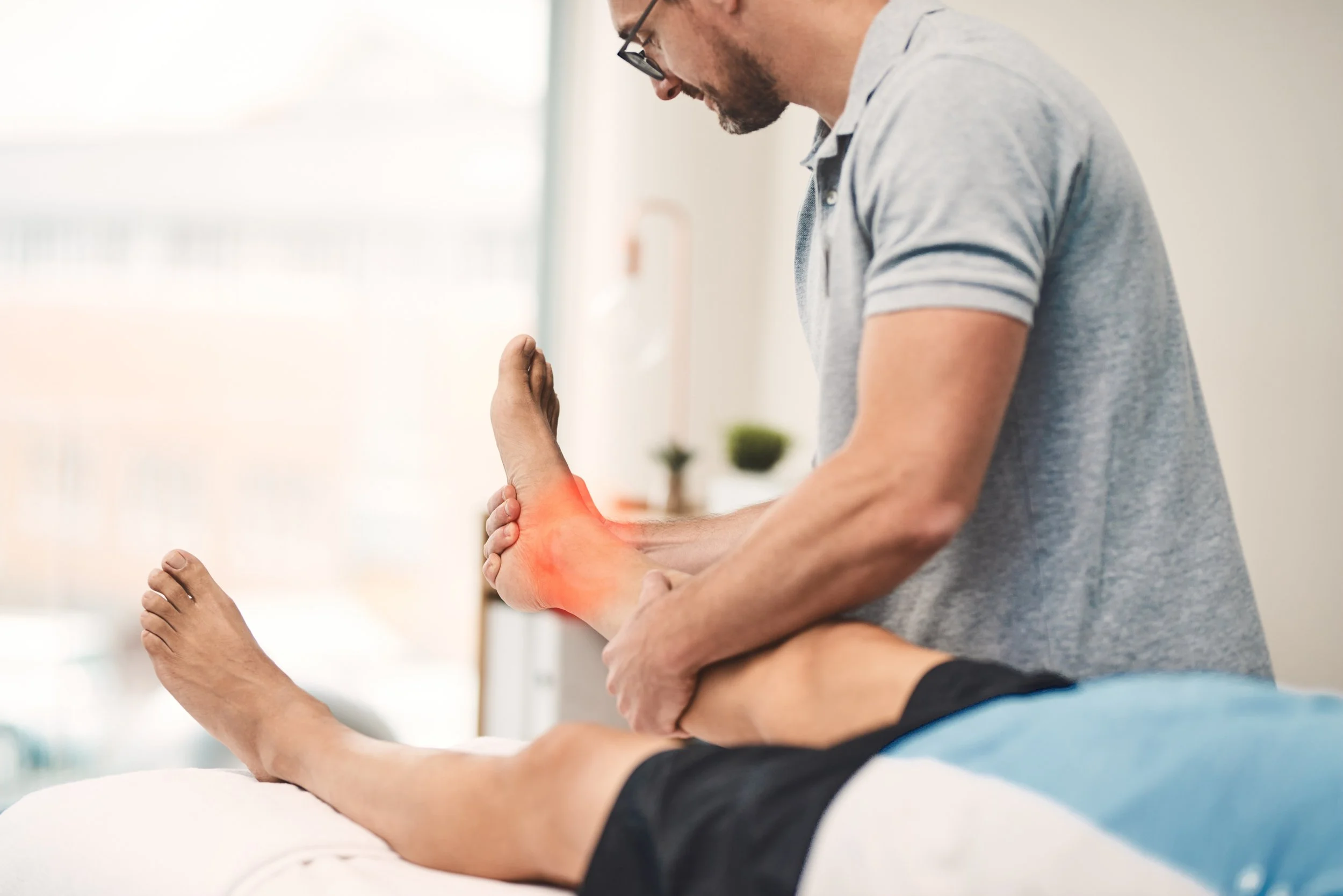 A physical therapist perform manual ankle joint mobilization and guided movement therapy to treat instability and restore function to a patient’s ankle.