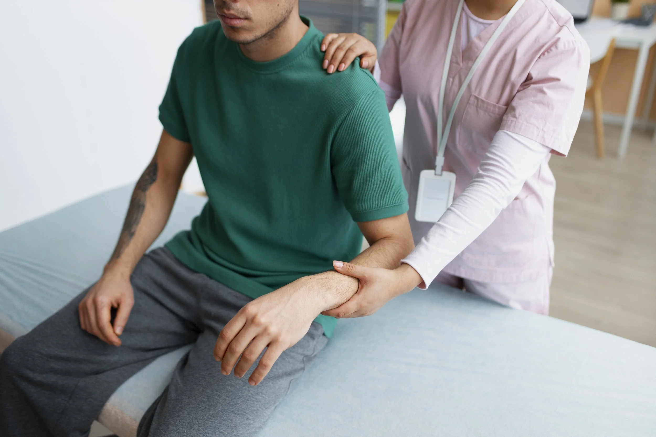 A professional physical therapist at Signature PT performing manual joint mobilization and stretching on a patient’s wrist to treat arthritis pain.