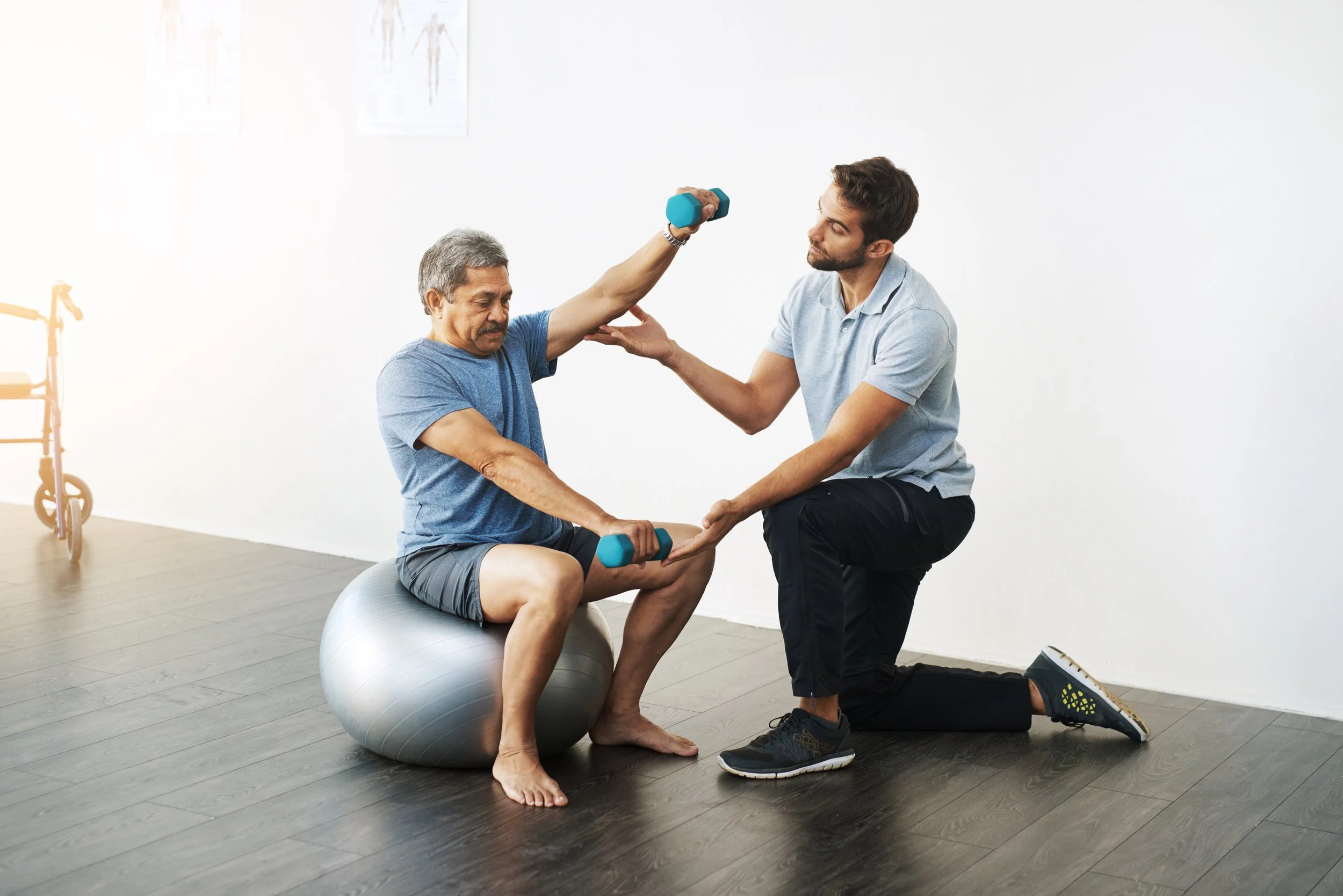 A physical therapist perform a guided vestibular rehabilitation exercise with a patient on a treatment table using specialized red sling equipment in Manhattan.
