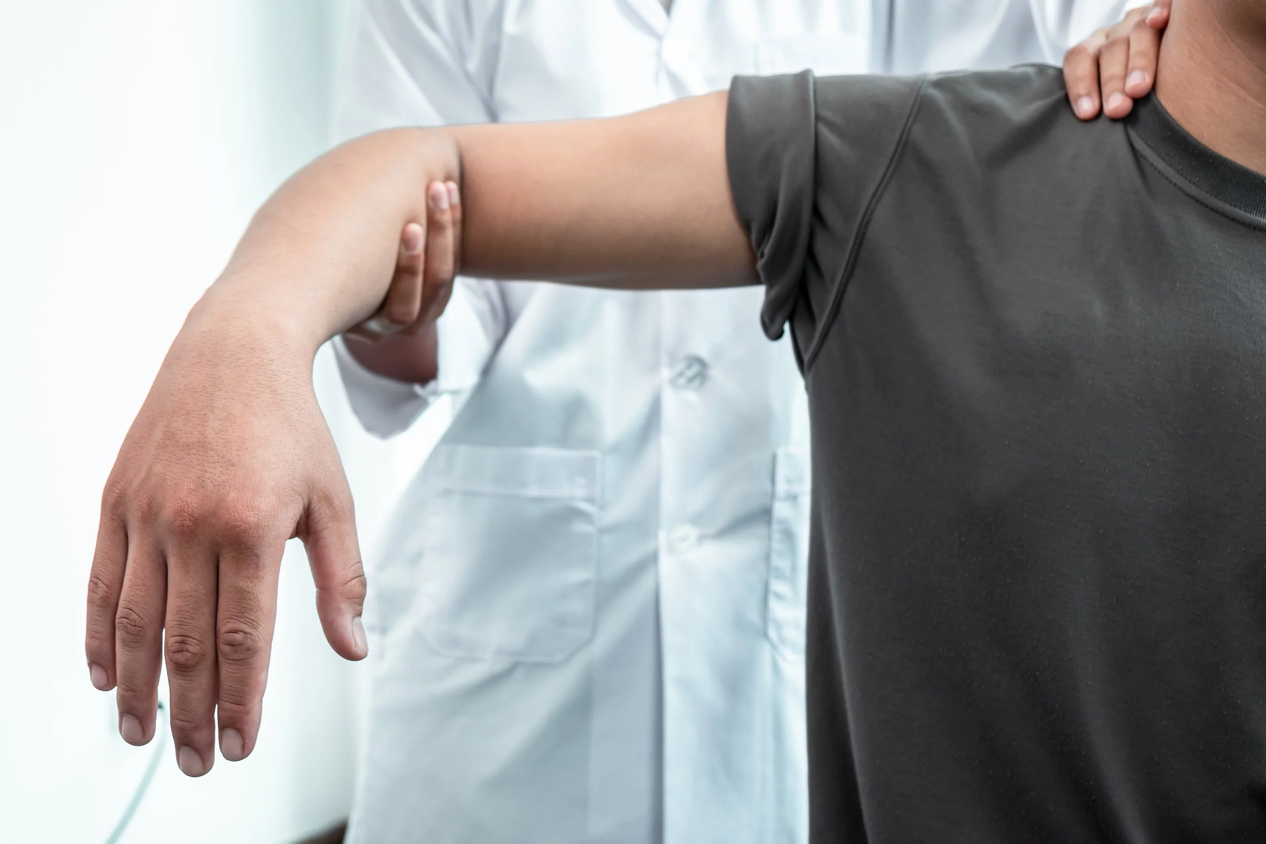 A physical therapist at Signature PT perform manual joint mobilization and guided movement therapy on a patient’s elbow to restore function.
