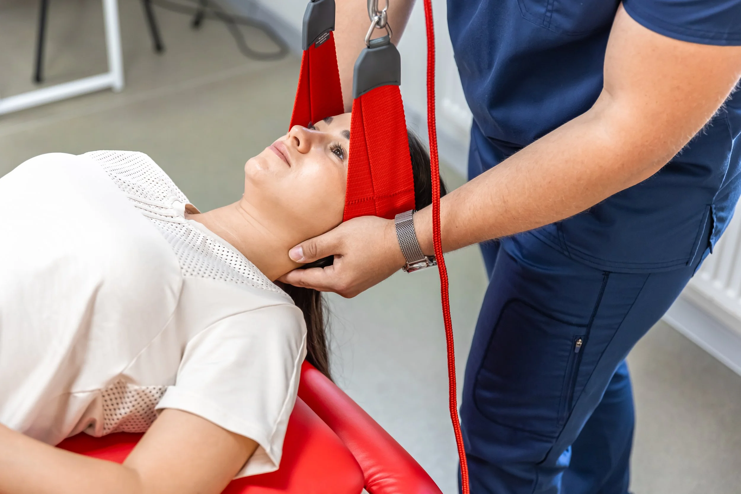 A physical therapist guiding a patient's head during a specialized vestibular rehabilitation maneuver to treat inner ear disorders and resolve vertigo symptoms.