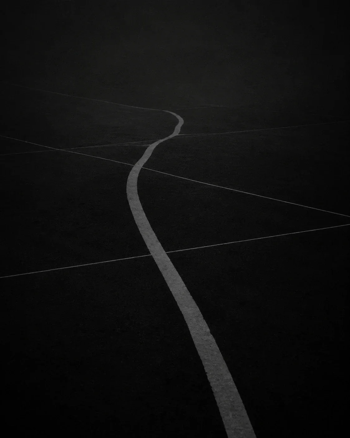 Ligne blanche sinueuse traversant plusieurs lignes droites sur une surface sombre, illustrant la difficulté de garder tout sous contrôle