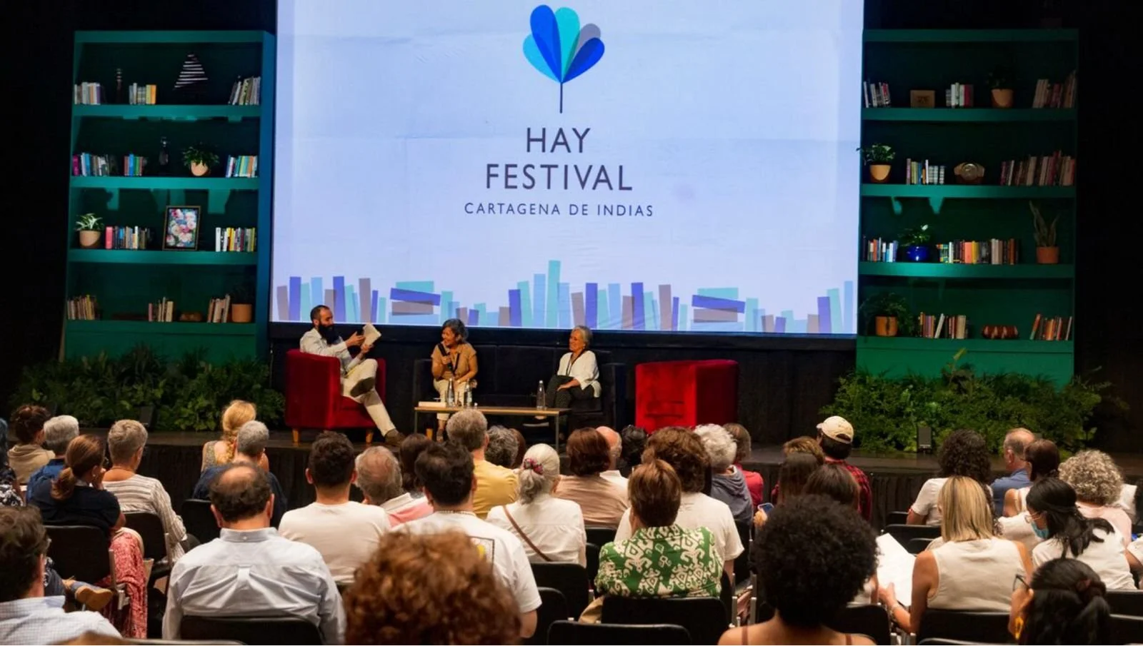 Conferencia en un auditorio con audiencia, en el escenario hay un panel de tres personas y una pantalla que dice "Hay Festival Cartagena de Indias".