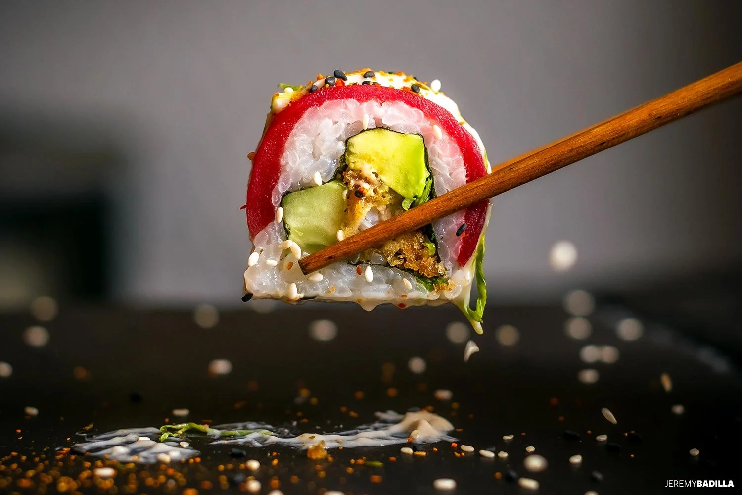 Sushi con pepino, aguacate y semillas, con palillo de madera, sobre una superficie negra