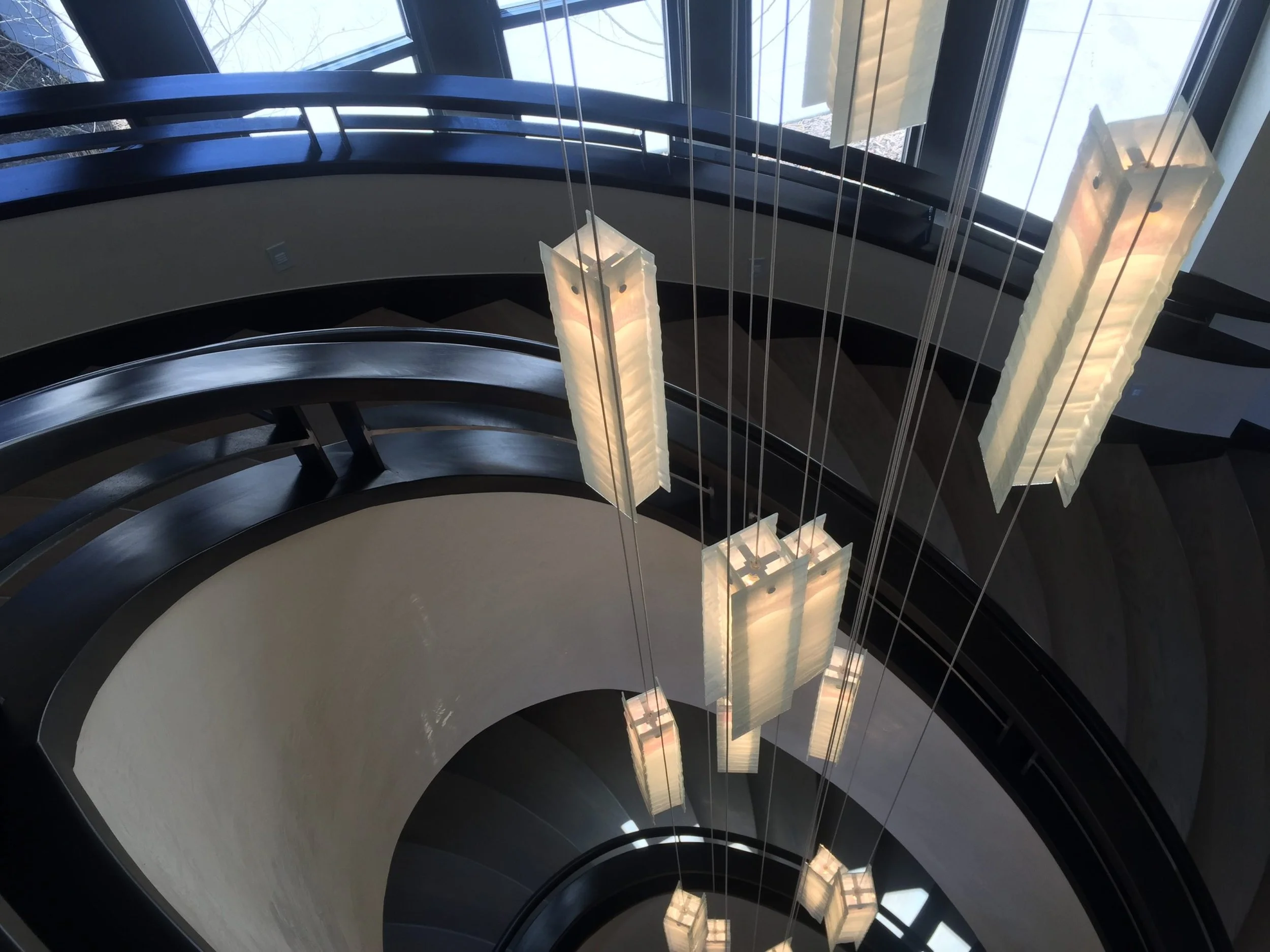 Light feature dangling through custom steel curved stair
