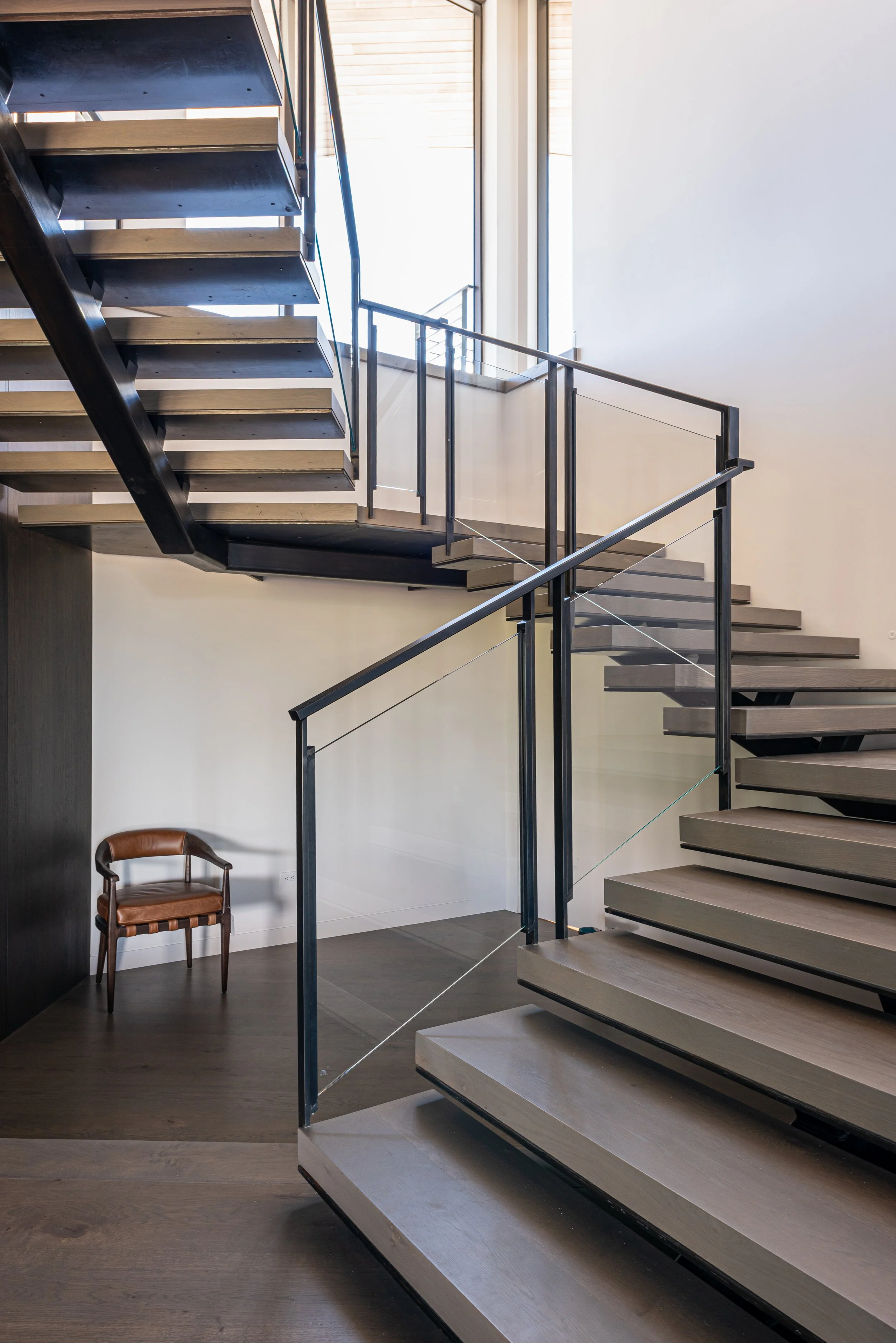 Mono stringer stair by Innovative with glass rail near base