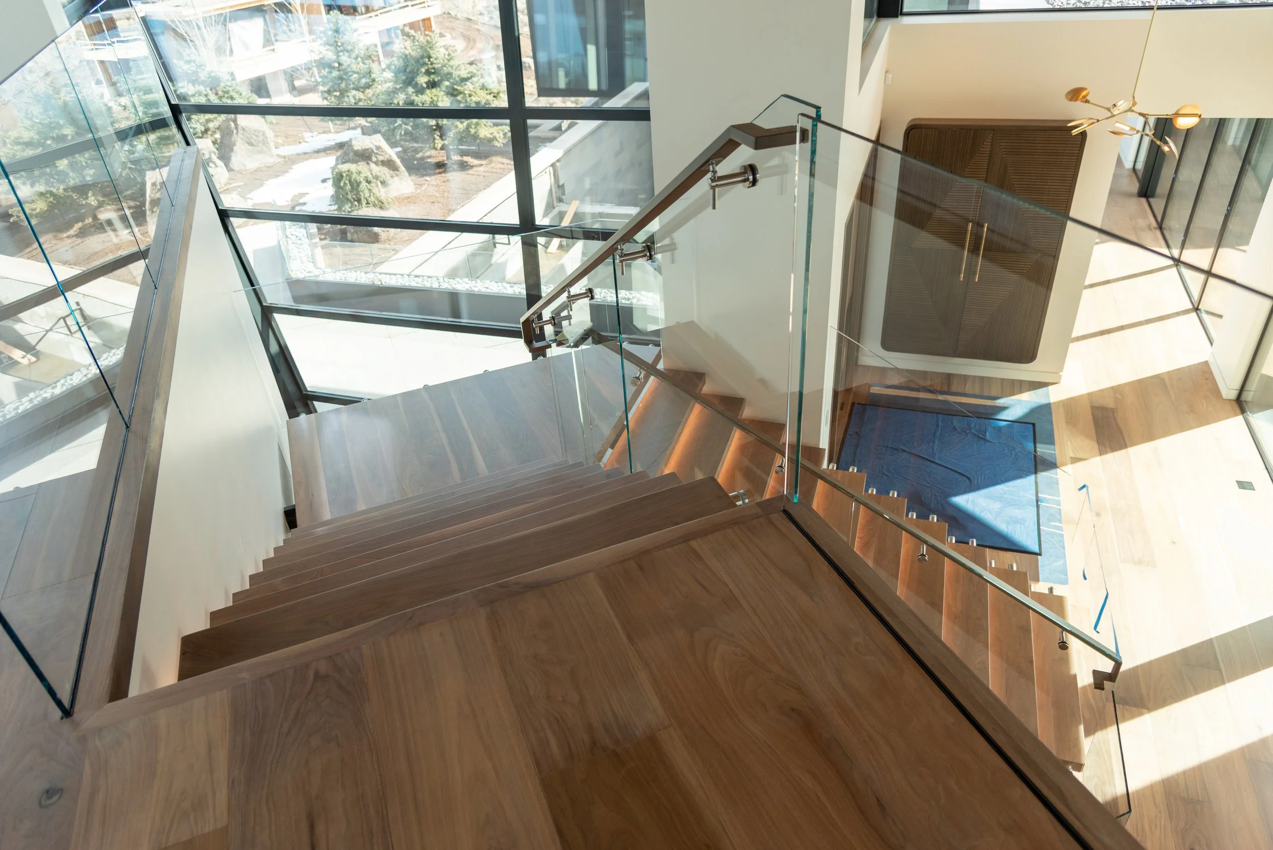 View of top run of treads on steel stair wrapped in wood tread